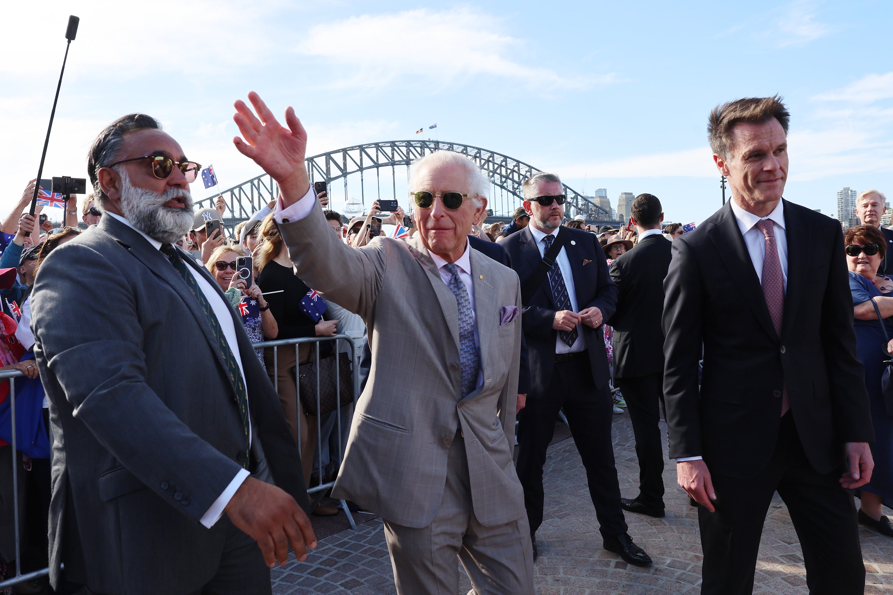 King Charles III waves to members of the public as he arrives at the Sydney Opera House