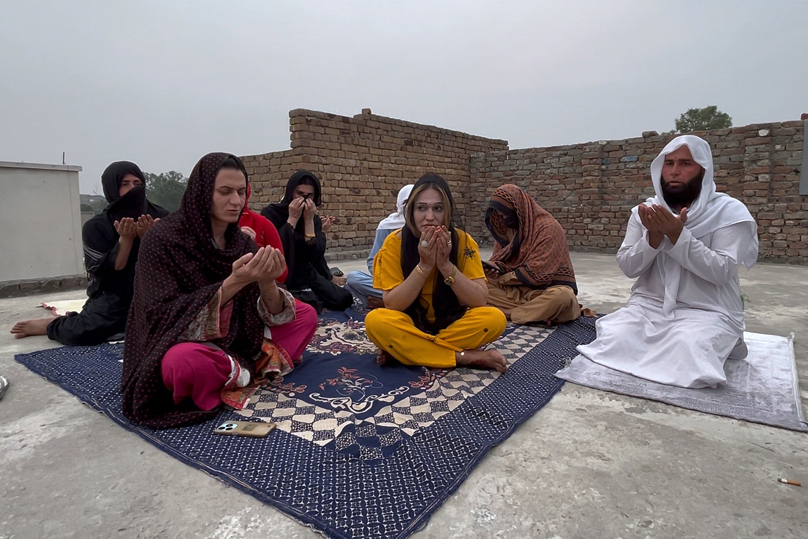 A Muslim cleric and transgender persons attend a prayer ceremony for their colleagues, who were killed by two men armed with daggers at their home, in Mardan, a city in Pakistan's Khyber Pakhtunkhwa province