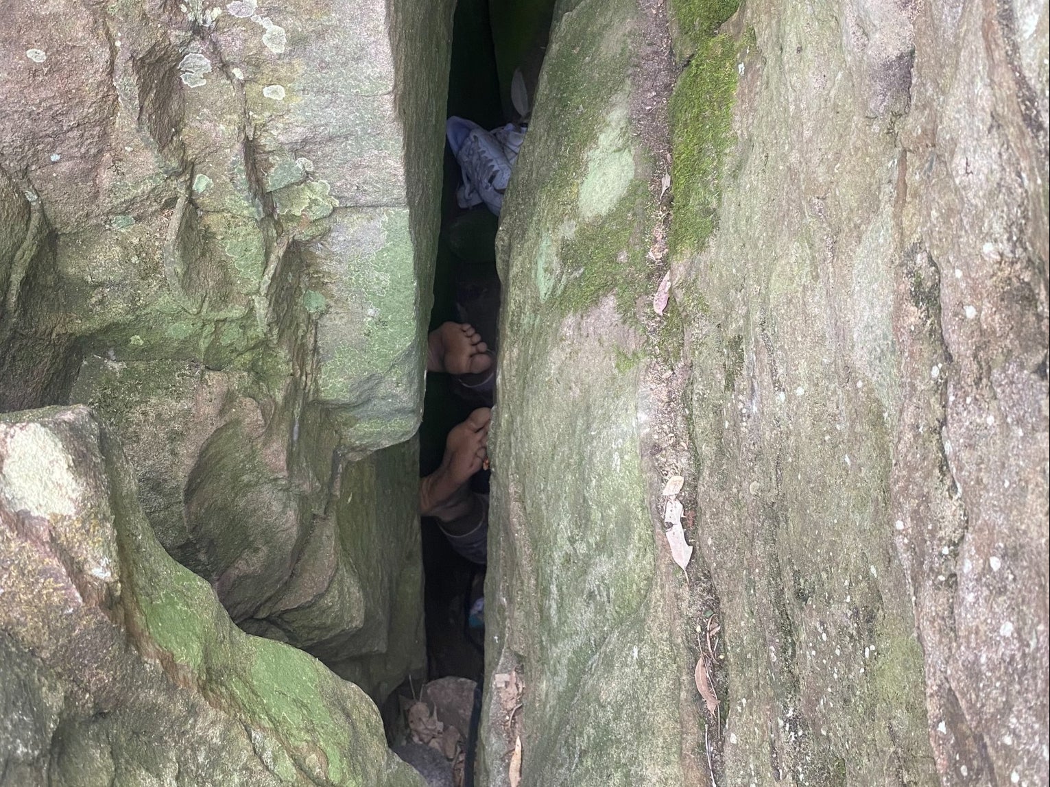 The woman became trapped between the boulders while trying to reach her phone