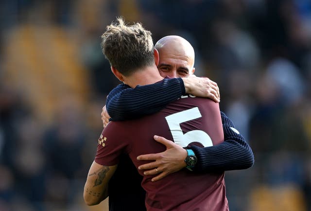 <p>Pep Guardiola embraces John Stones after the defender’s goal at Molineux</p>