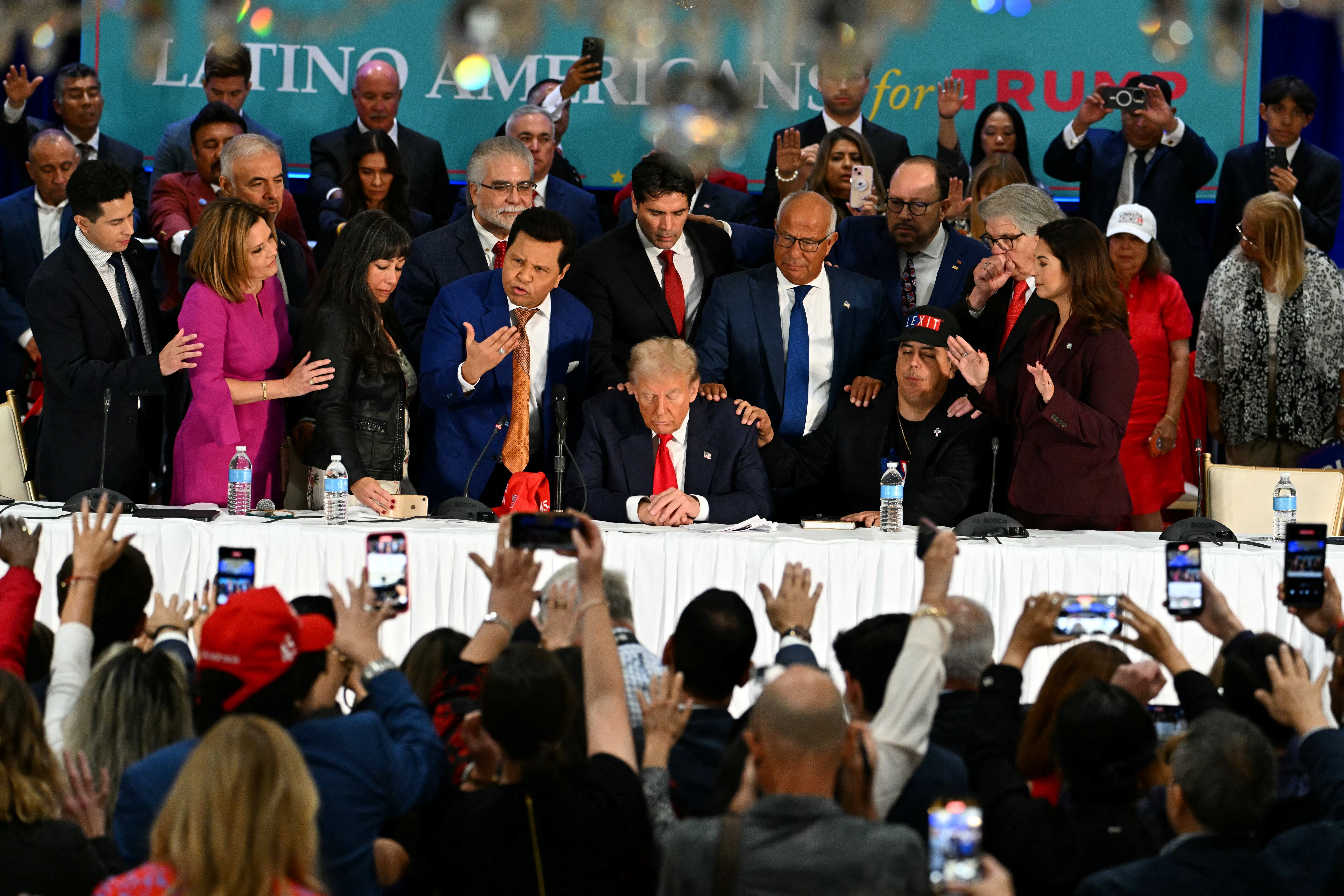 Former US President and Republican presidential candidate Donald Trump prays during a roundtable discussion with Latino community leaders at Trump National Doral Miami resort in Miami, Florida, on October 22, 2024