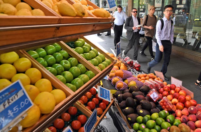 <p>People walk past a fruit stall in Sydney </p>