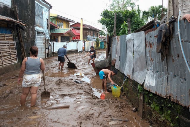 <p>People clean up after Trami caused floods in Polangui, Philippines, on 23 October 2024</p>
