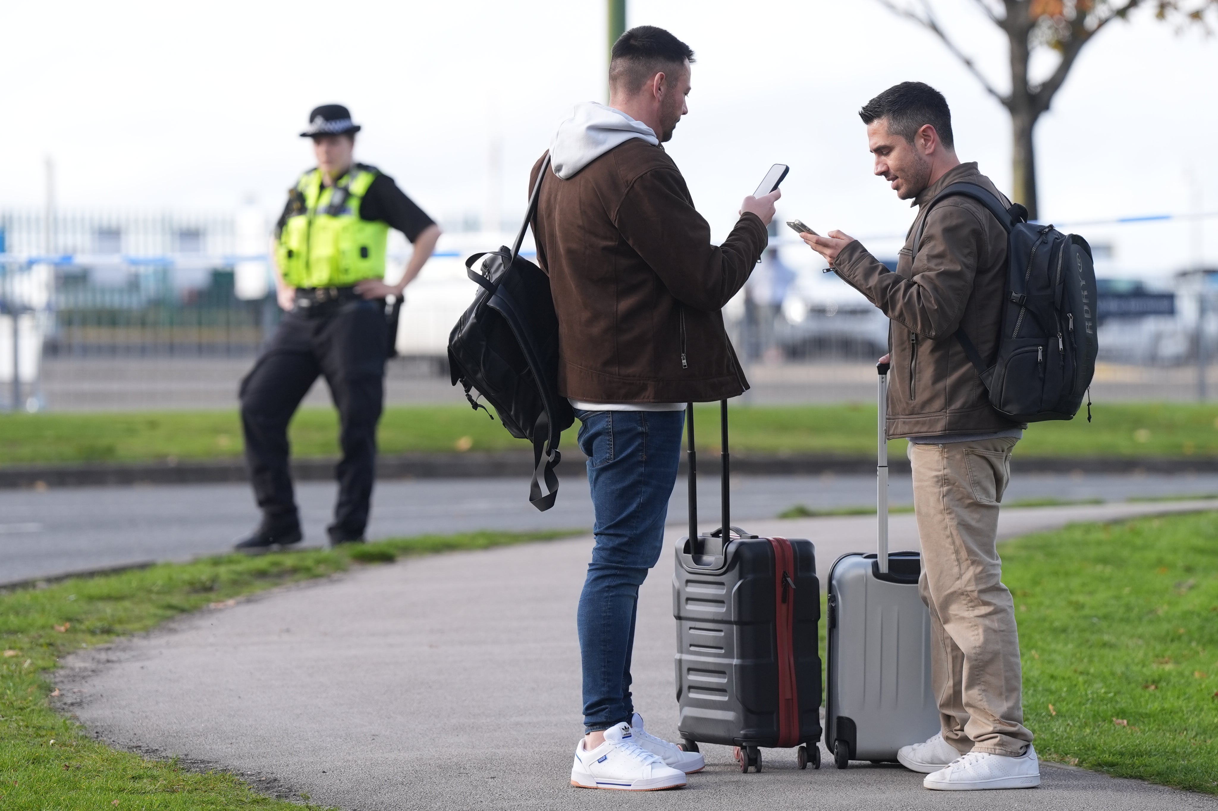 Passengers wait outside Birmingham Airport as flights were cancelled and delayed following a bomb scare