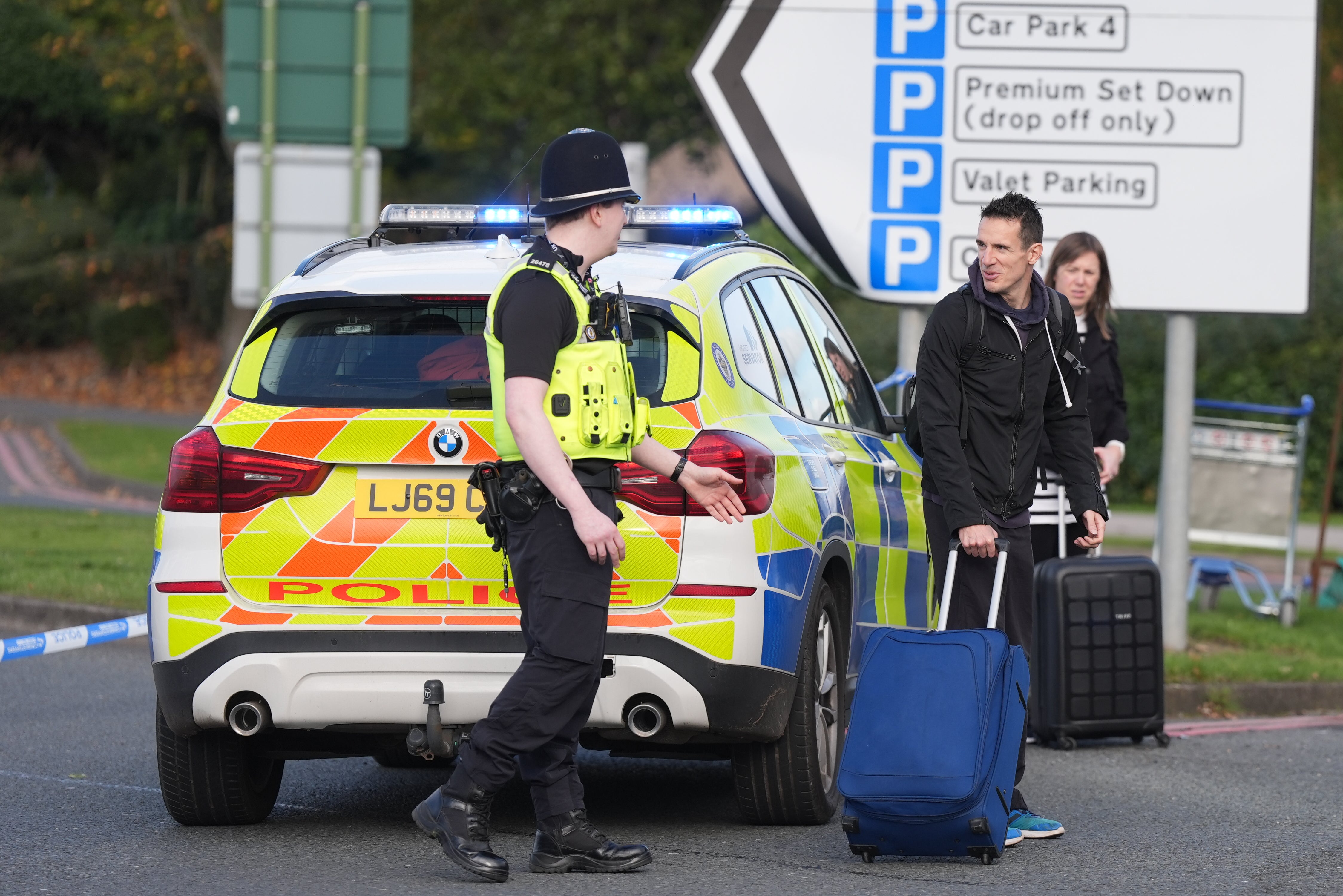 A police officer speaks to passengers after hundreds of people were forced to evacuate Birmingham Airport