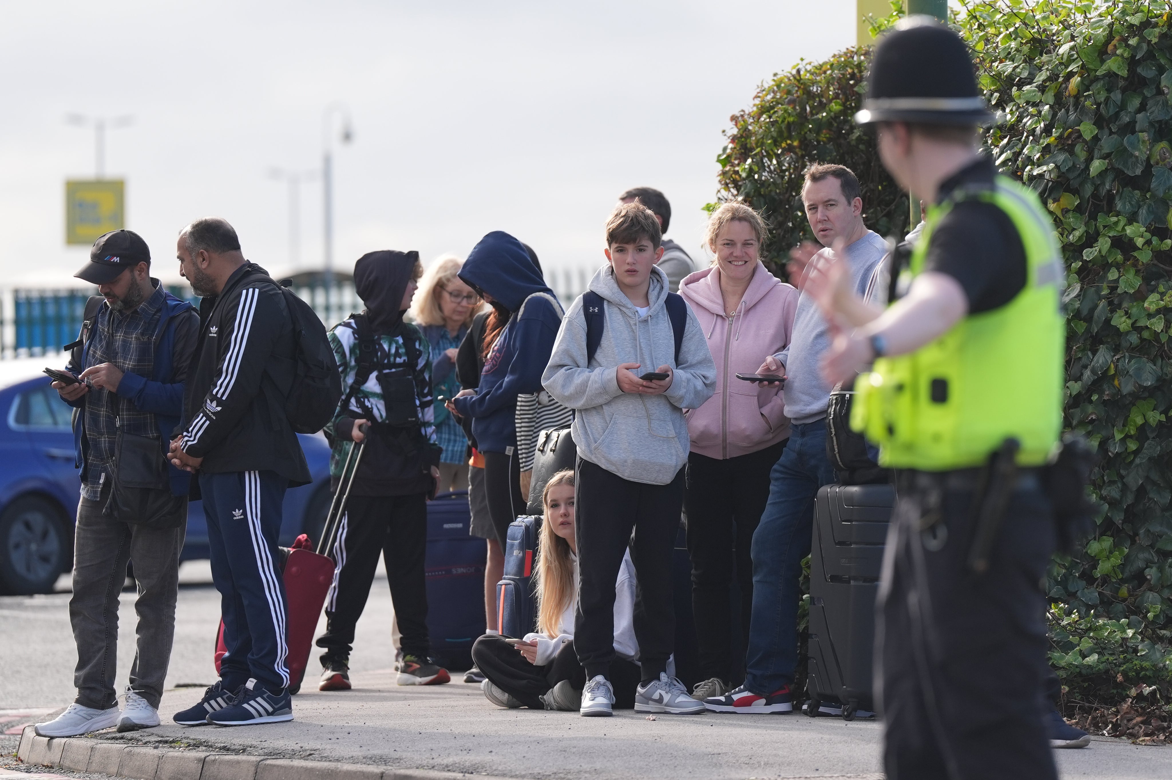 Passengers wait to enter Birmingham Airport after it was evacuated following a bomb scare