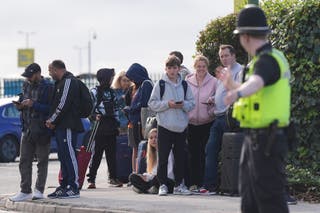 Passengers wait to enter Birmingham Airport after it was evacuated following a security alert