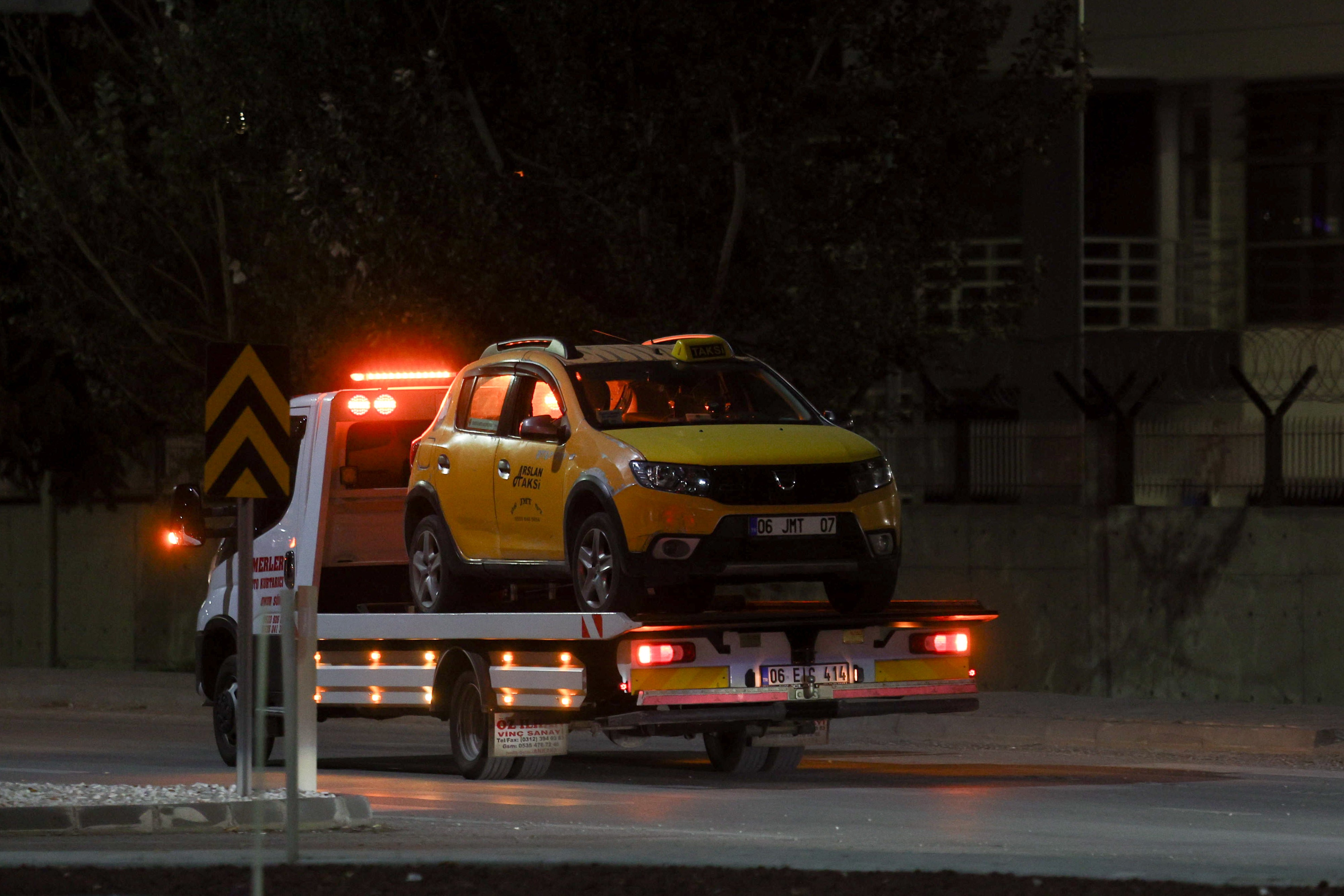 A taxi reportedly used by the attackers is towed away following reports of gunfire and explosions