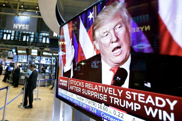 <p>Financial firms are adding more staff to handle an expected increase in trading as election results come in on November 5. Pictured: A TV screen at the New York Stock Exchange after Trump’s 2016 win </p>