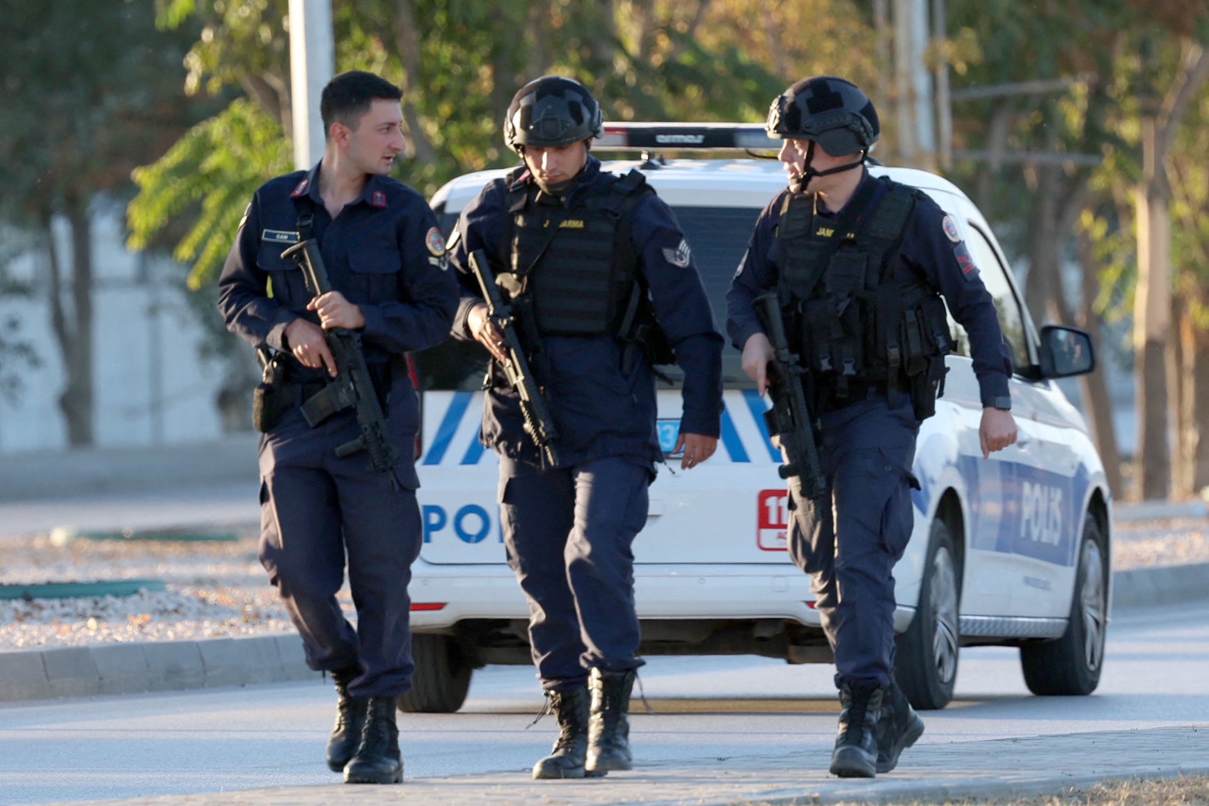 Turkish armed police walk nearby the gate of the Turkish Aerospace Industries following an attack on the site