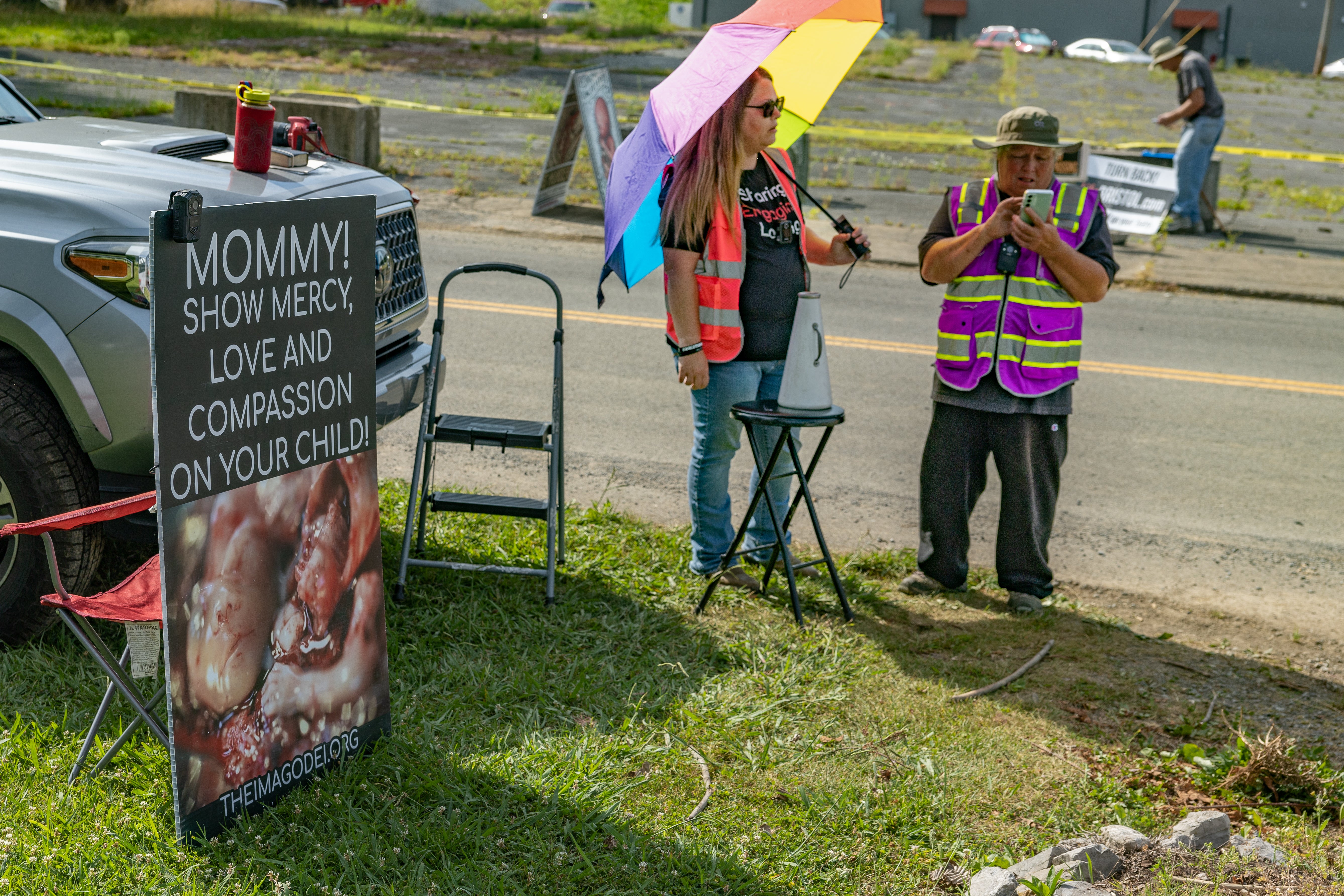 Some of the anti-abortion protesters, holding rainbow umbrellas and wearing bright vests, stand outside the Bristol clinic