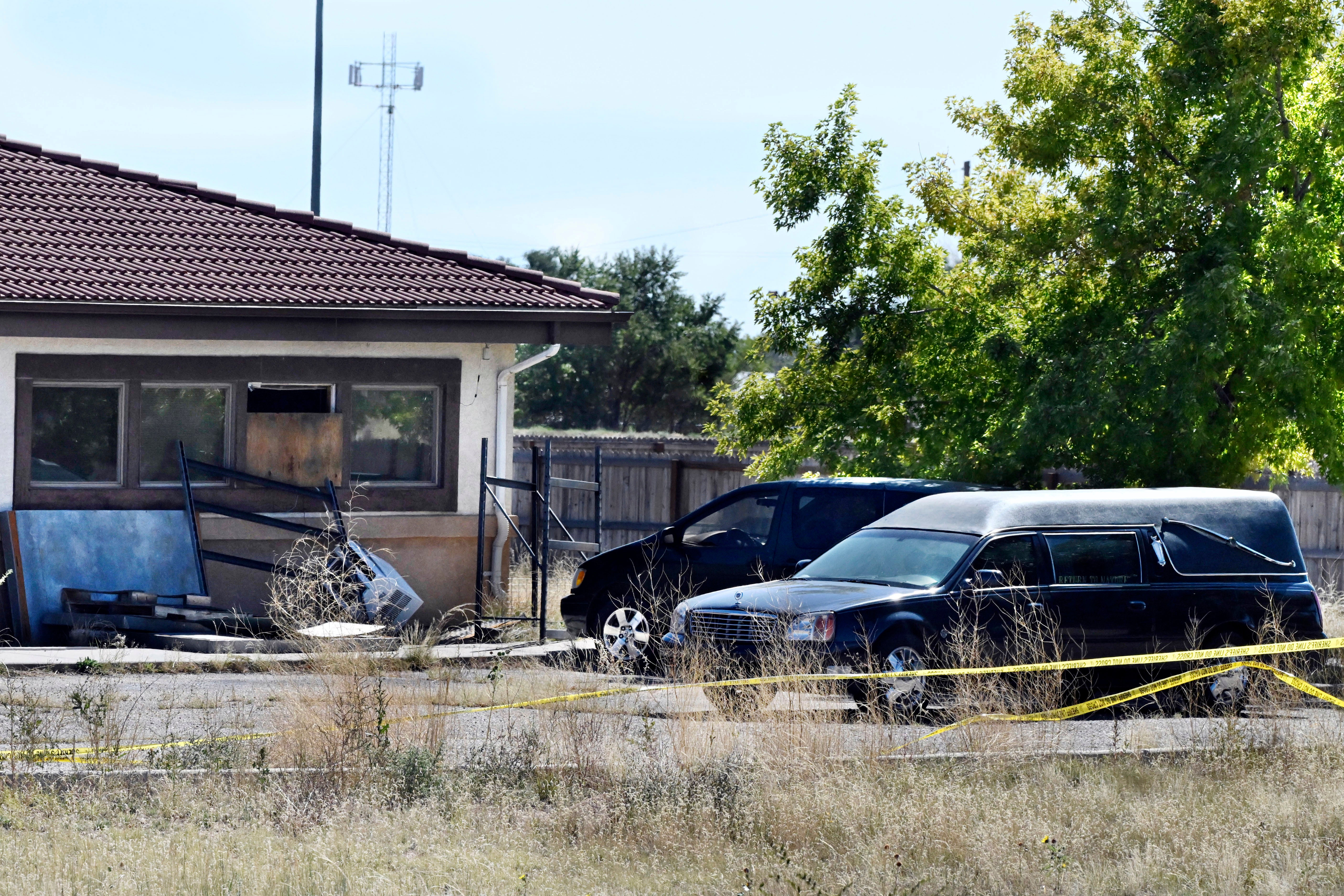 A hearse and debris can be seen at the rear of the Return to Nature Funeral Home, Oct. 5, 2023