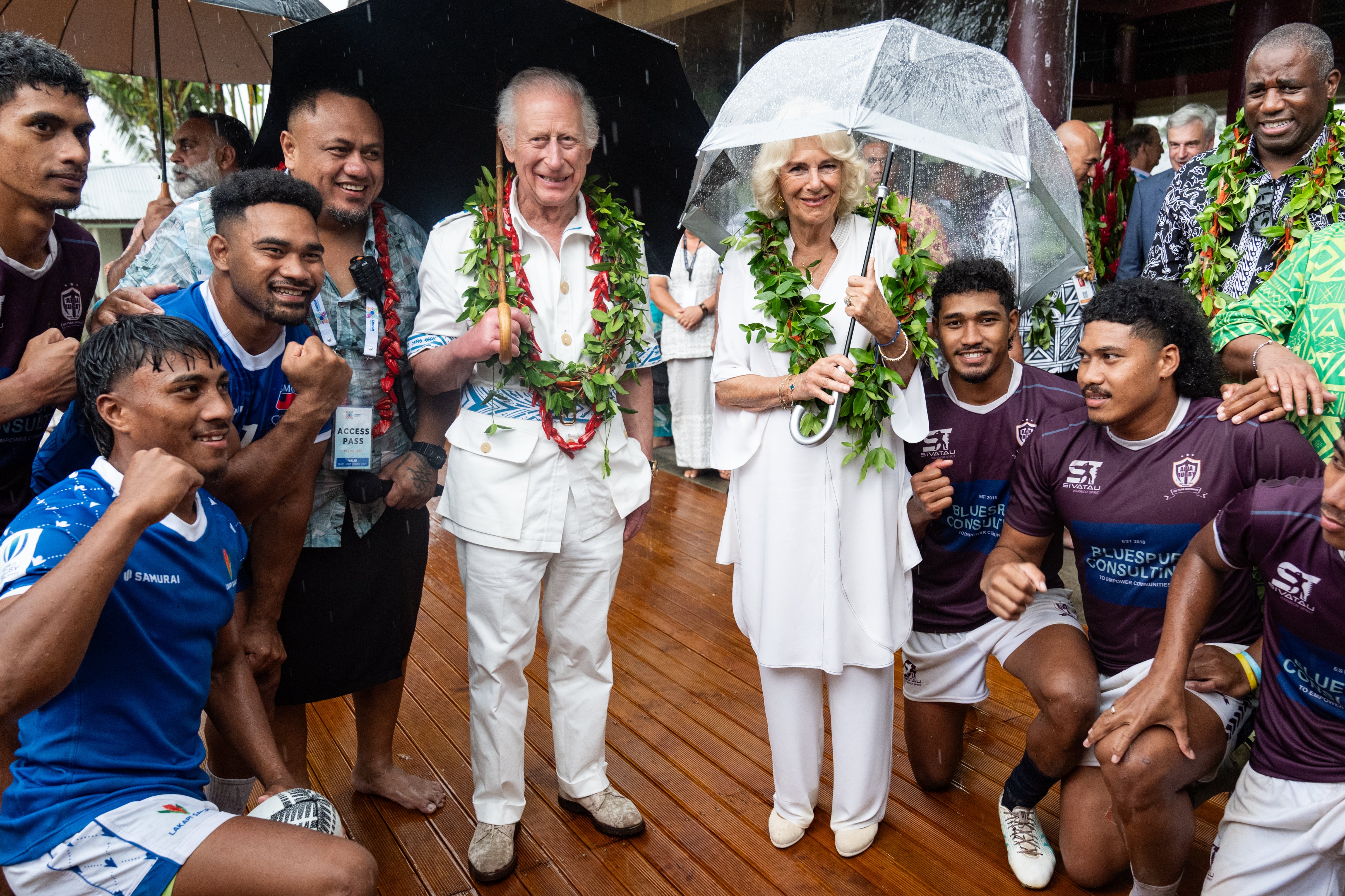 El rey Carlos y la reina Camilla con miembros del equipo de rugby de Apia durante una visita a la Villa Cultural de Samoa en Apia