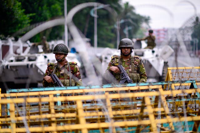 <p>Bangladesh army personnel stand guard behind barbed wire and barricades at the entrance of the residence of president Mohammed Shahabuddin in Dhaka, 23 Oct 2024</p>