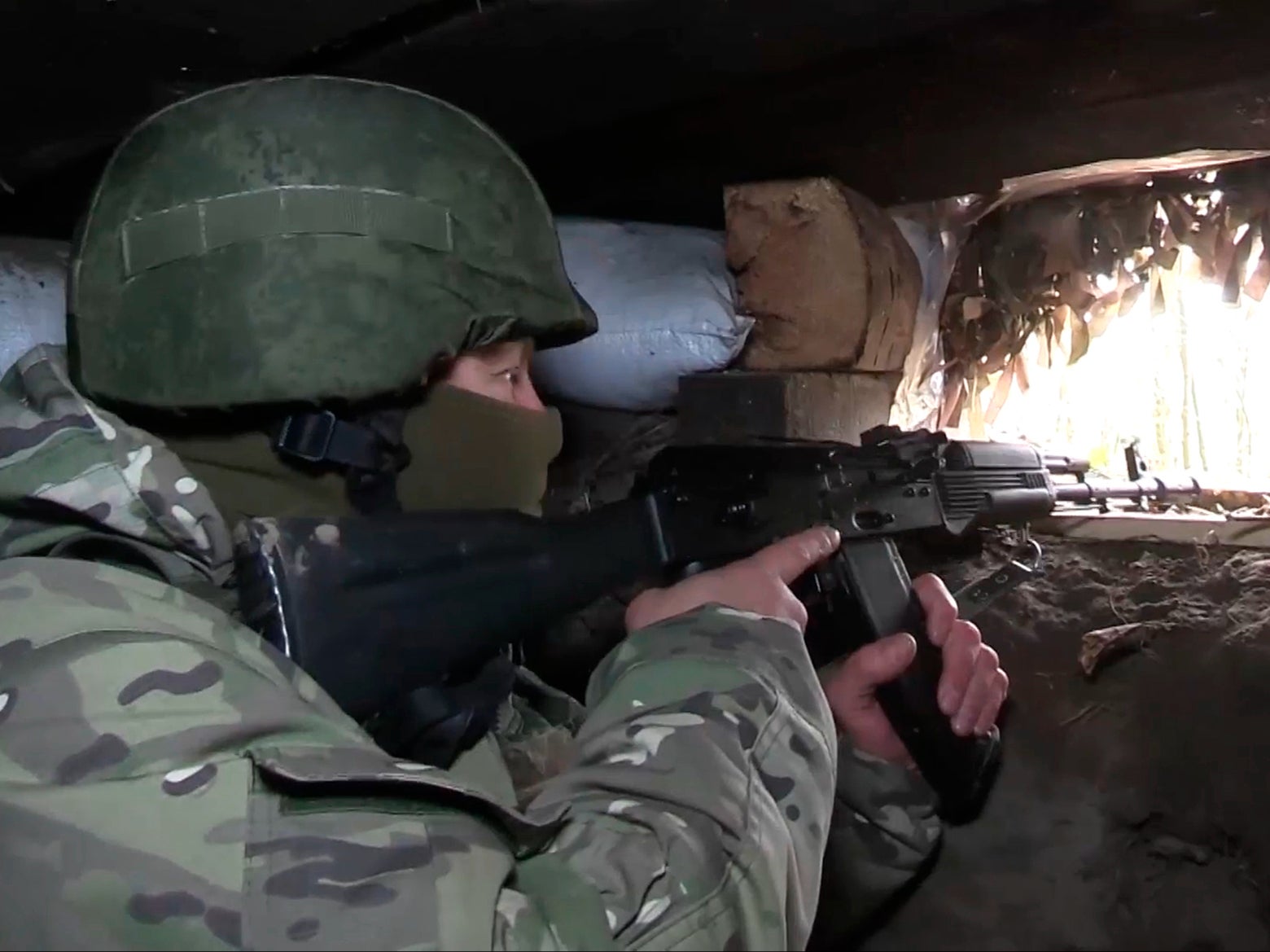 In this photo taken from video released by the Russian Defense Ministry, a Russian soldier aims from a bunker in the Russian - Ukrainian border area in the Kursk region, Russia