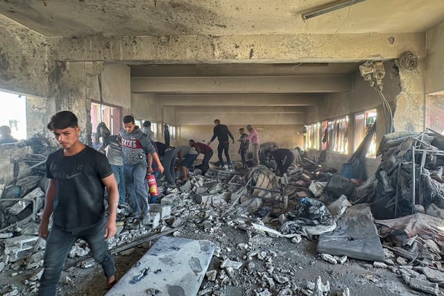 <p>Palestinians inspect the aftermath of the attack on a school that was housing displaced people </p>