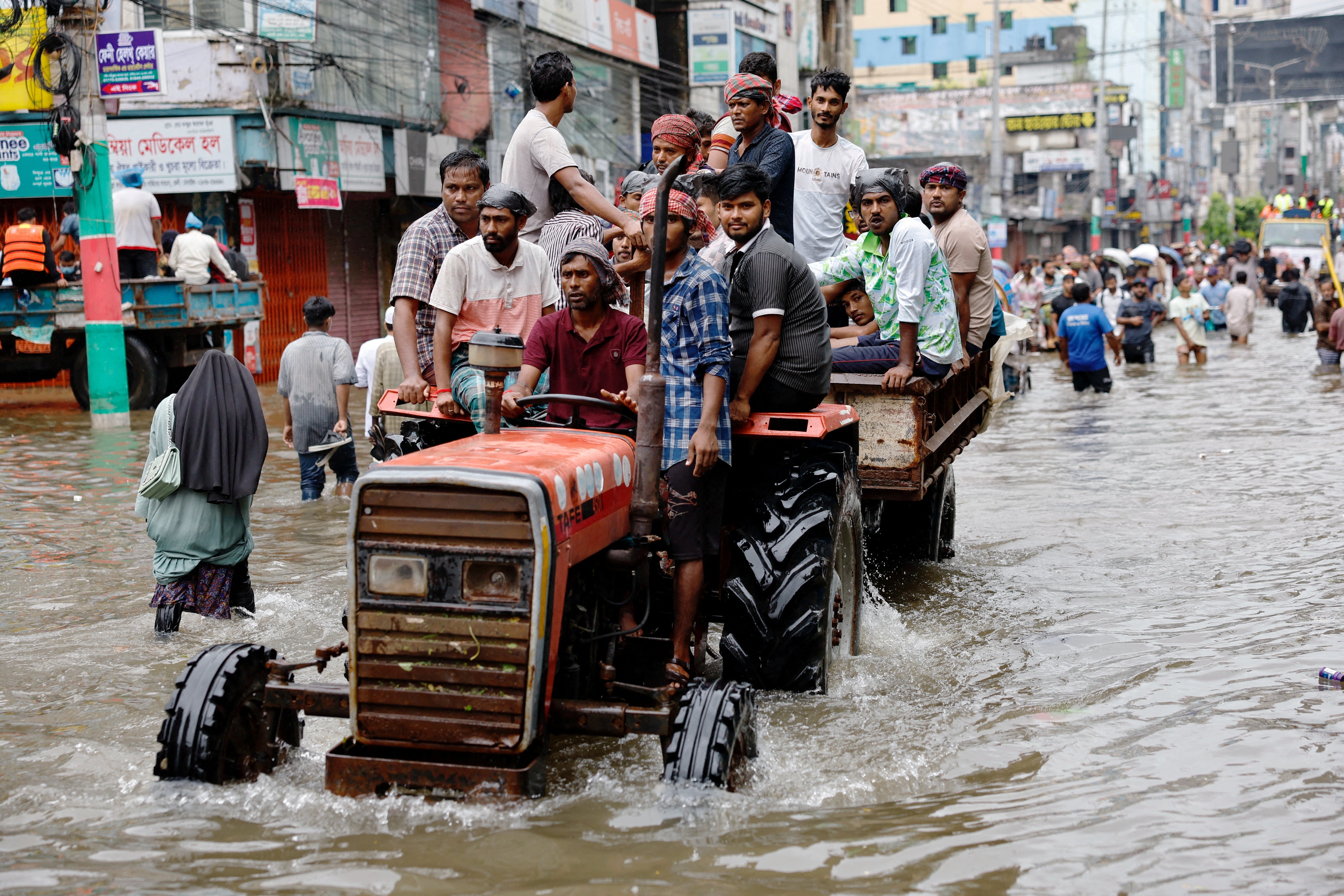 People ride a tractor amid severe flooding in Feni, Bangladesh, in August 2024. Scientists have warned that there is no safe amount of climate change, but passing the 1.5-degree threshold would bring impacts to ecosystems that are larger than the world is willing to accept.