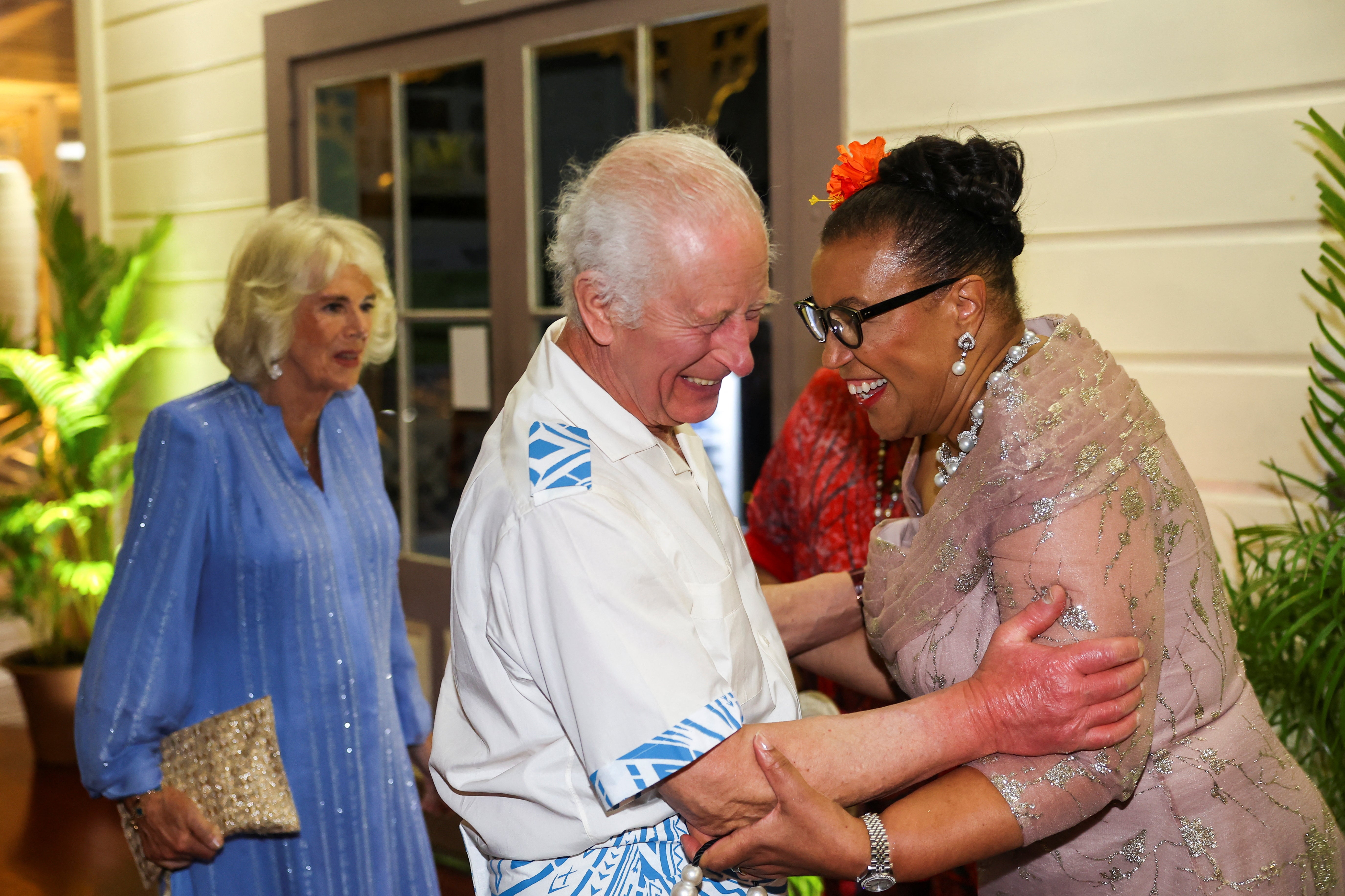 King Charles reacts with Commonwealth Secretary General Patricia Scotland near Queen Camilla as they arrive to attend the CHOGM opening summit