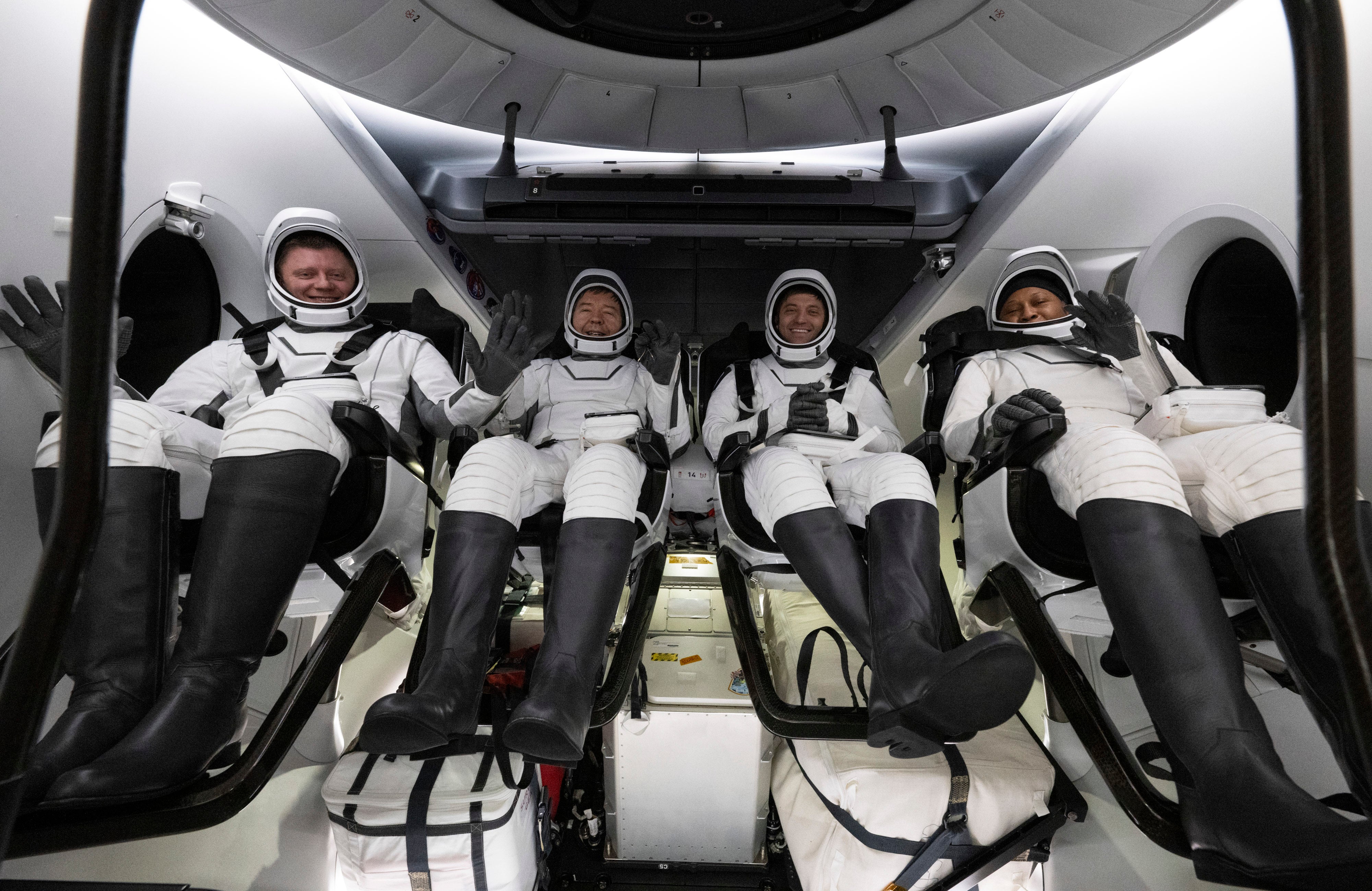 Roscosmos cosmonaut Alexander Grebenkin, left, NASA astronauts Michael Barratt, second from left, Matthew Dominick, second from right, and Jeanette Epps, right, sit inside the SpaceX Dragon Endeavour spacecraft