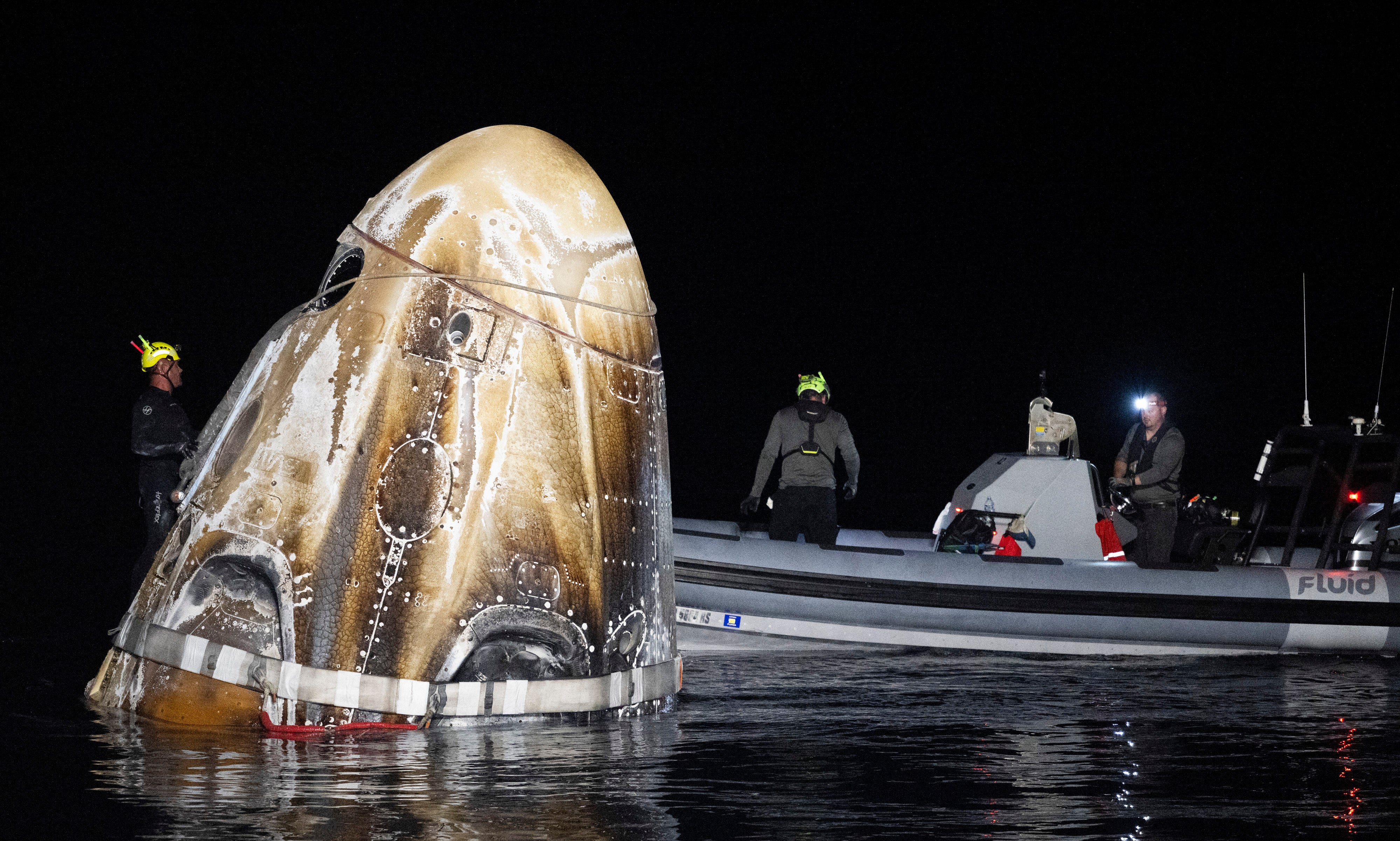 Support teams work around the SpaceX Dragon Endeavour spacecraft shortly after it landed in the waters near Pensacola, Florida, on Friday morning. The capsule’s crew safely splashed down after spending more than 235 days in space.