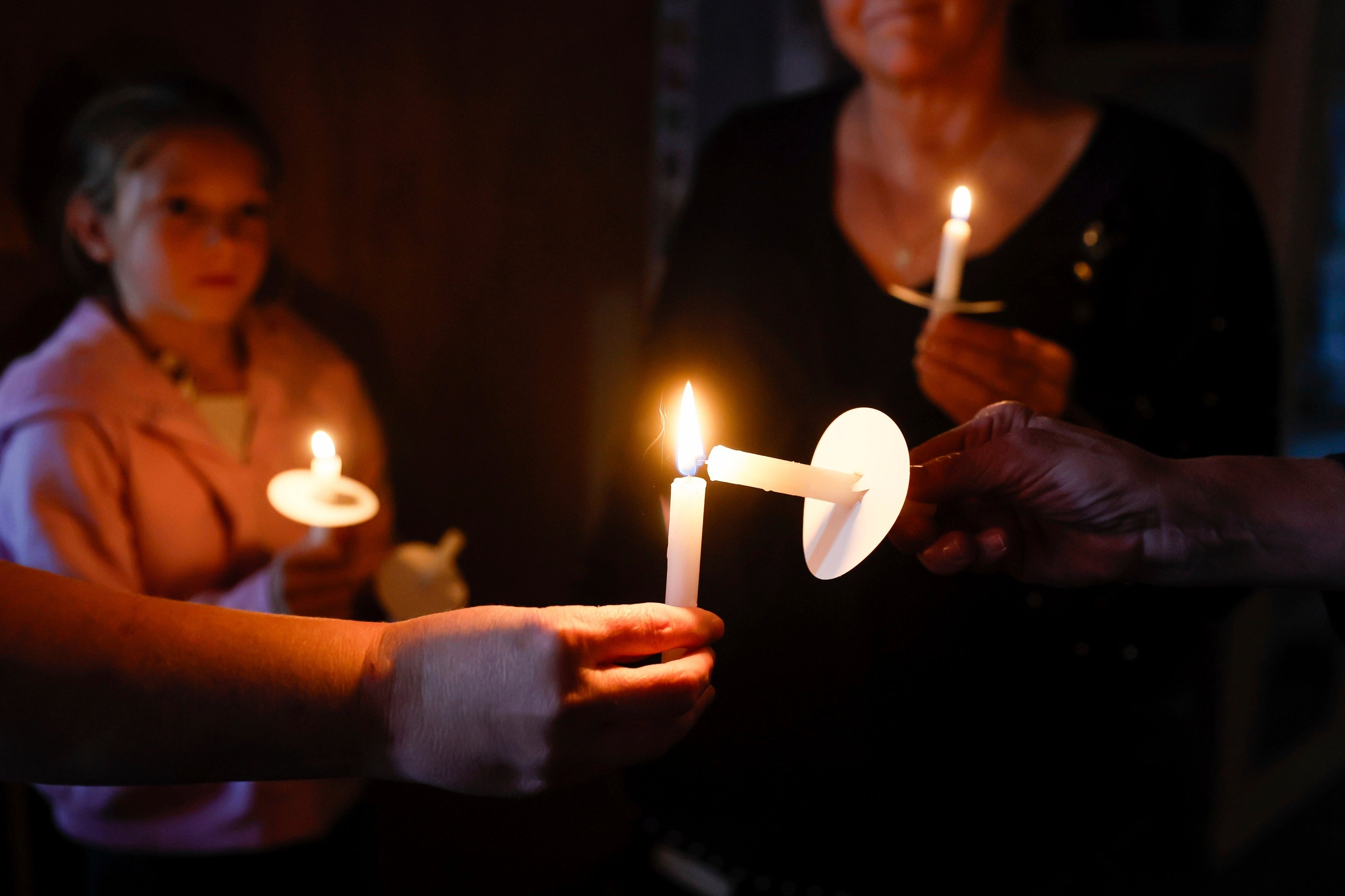 Community members attend a vigil for the Humistons on Tuesday. Their 15-year-old son, who faces charges for the deaths of his parents and three of his siblings, told police his 11-year-old brother committed the murders before taking his own life