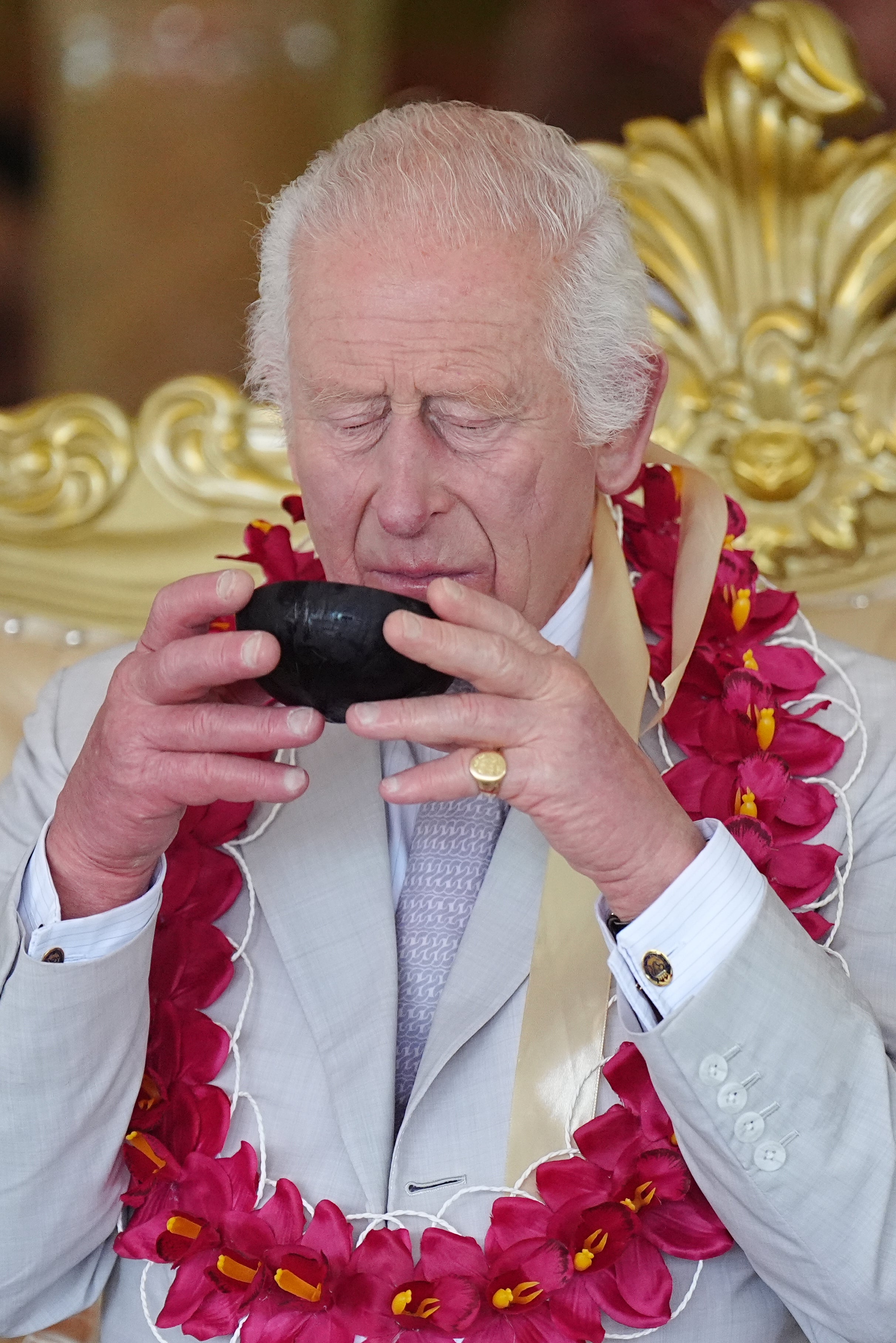 Charles drinks kava from a coconut shell (Aaron Chown/PA)