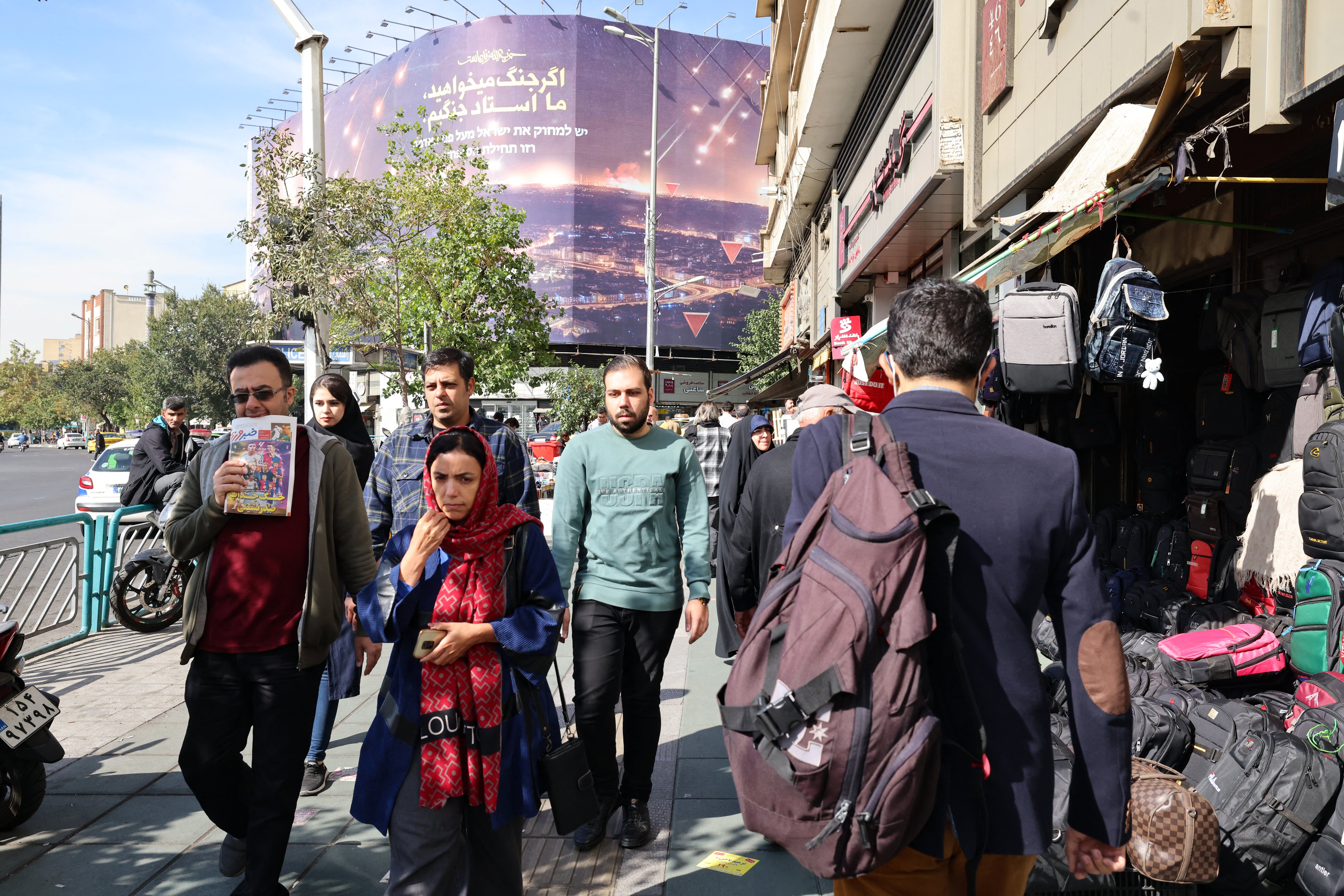 People walk along a street in Tehran on October 26, 2024. Residents of Tehran awoke and went about their business as planned on October 26 after their sleep was troubled by Israeli strikes that triggered blasts that echoed across the city