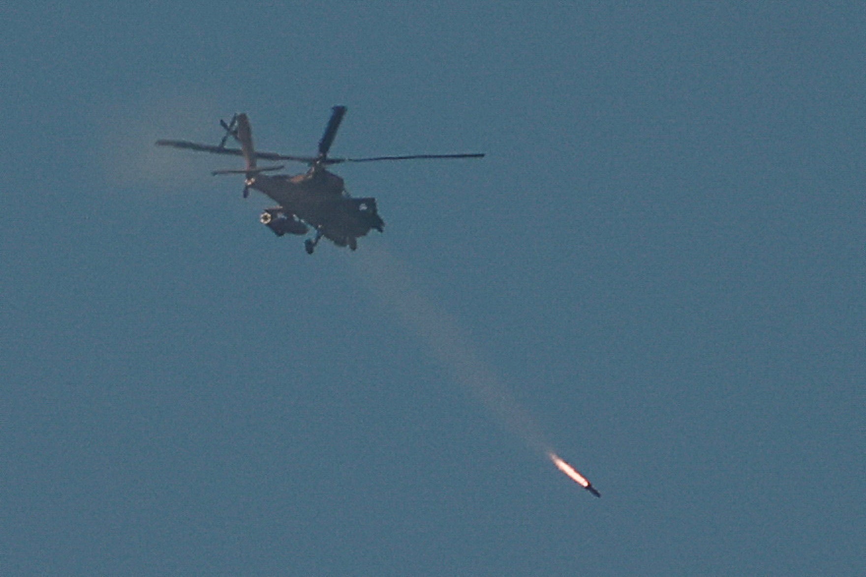 An Israeli Apache attack helicopter fires a missile towards southern Lebanon, amid ongoing hostilities between Hezbollah and Israel, as seen from near Ein Ya'akov, northern Israel