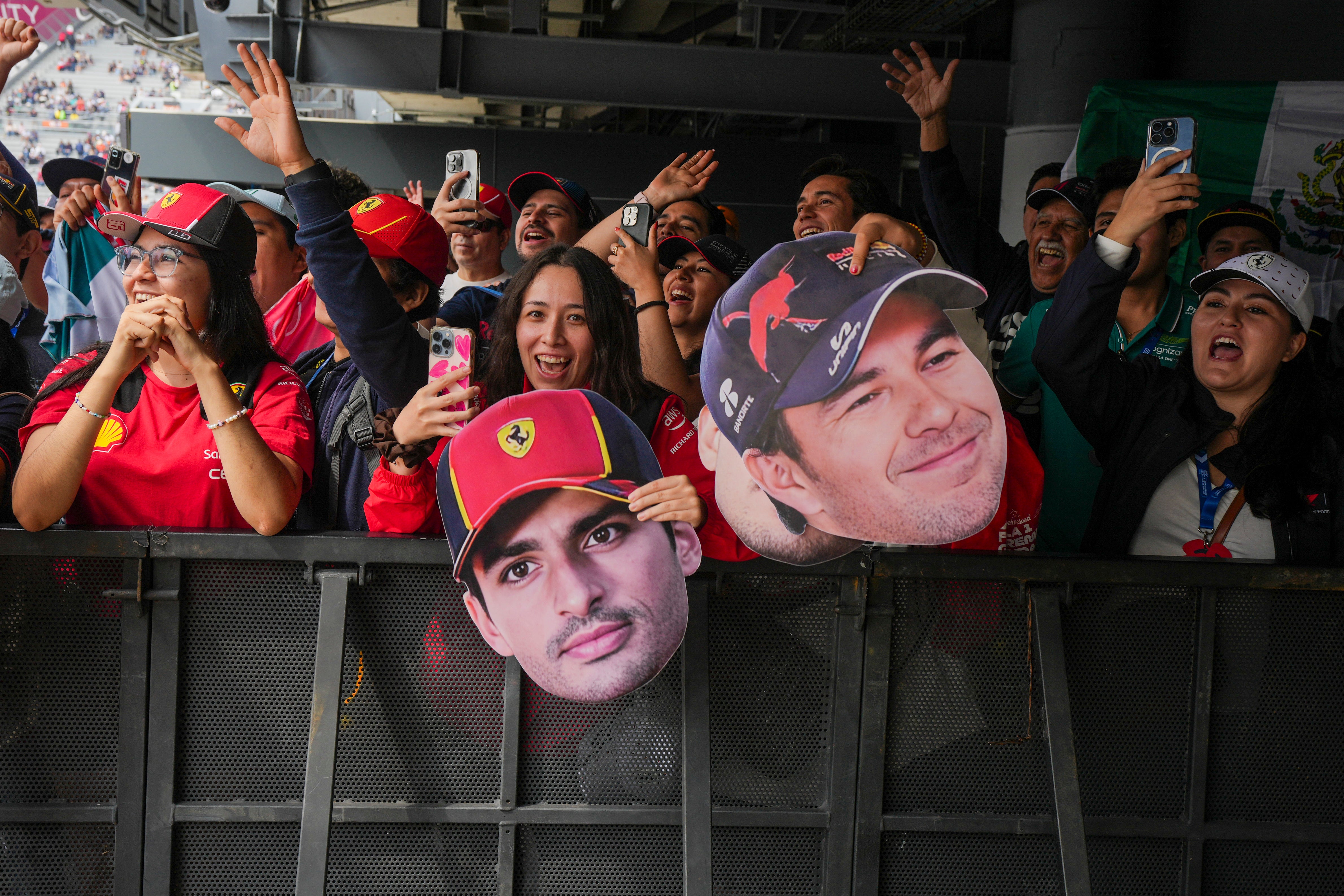 Fans hold cutouts of Ferrari driver Carlos Sainz, center, of Spain, and Red Bull driver Sergio Perez, of Mexico, during the third free practice