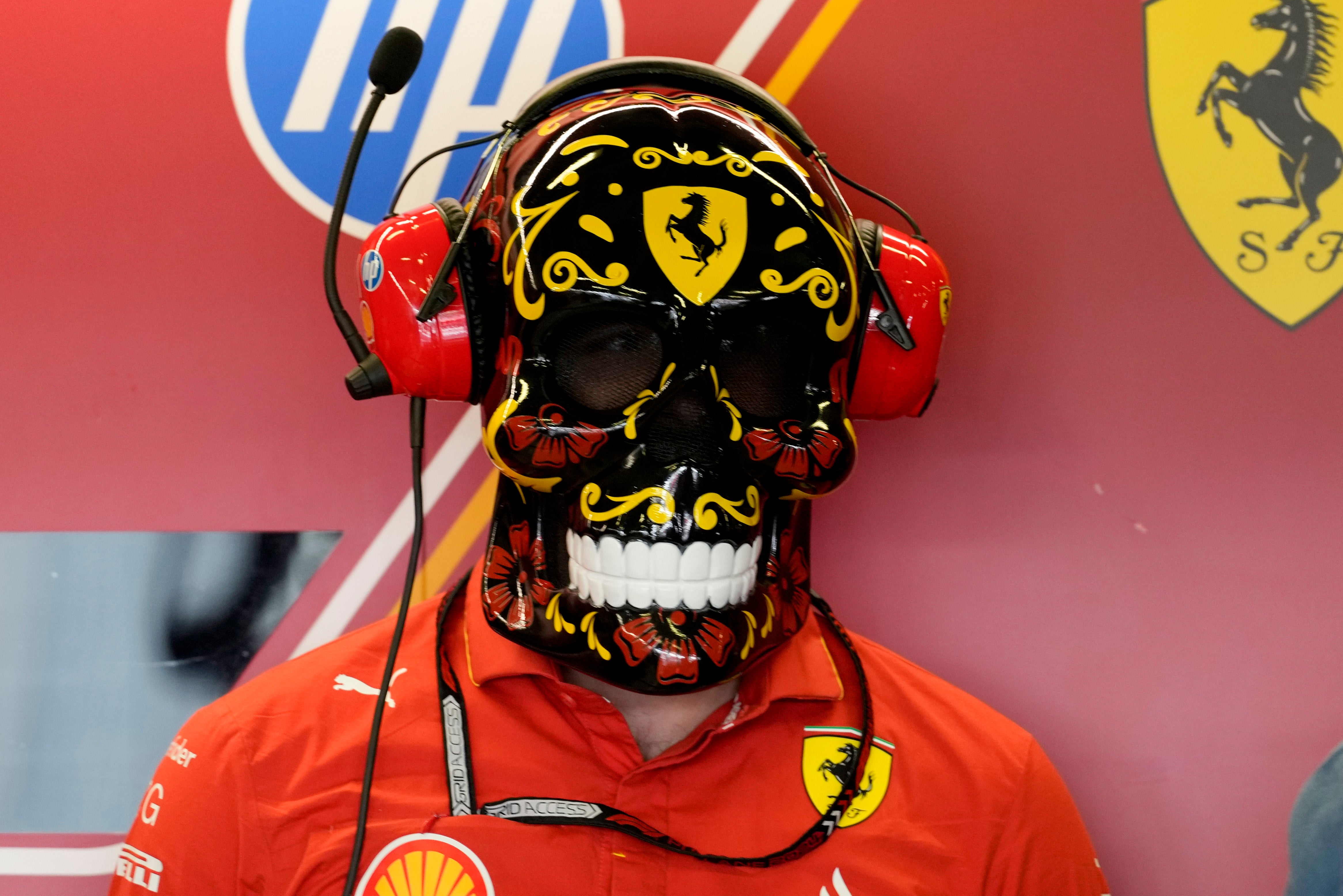 A Ferrari team member wears a Day of the Dead skull mask