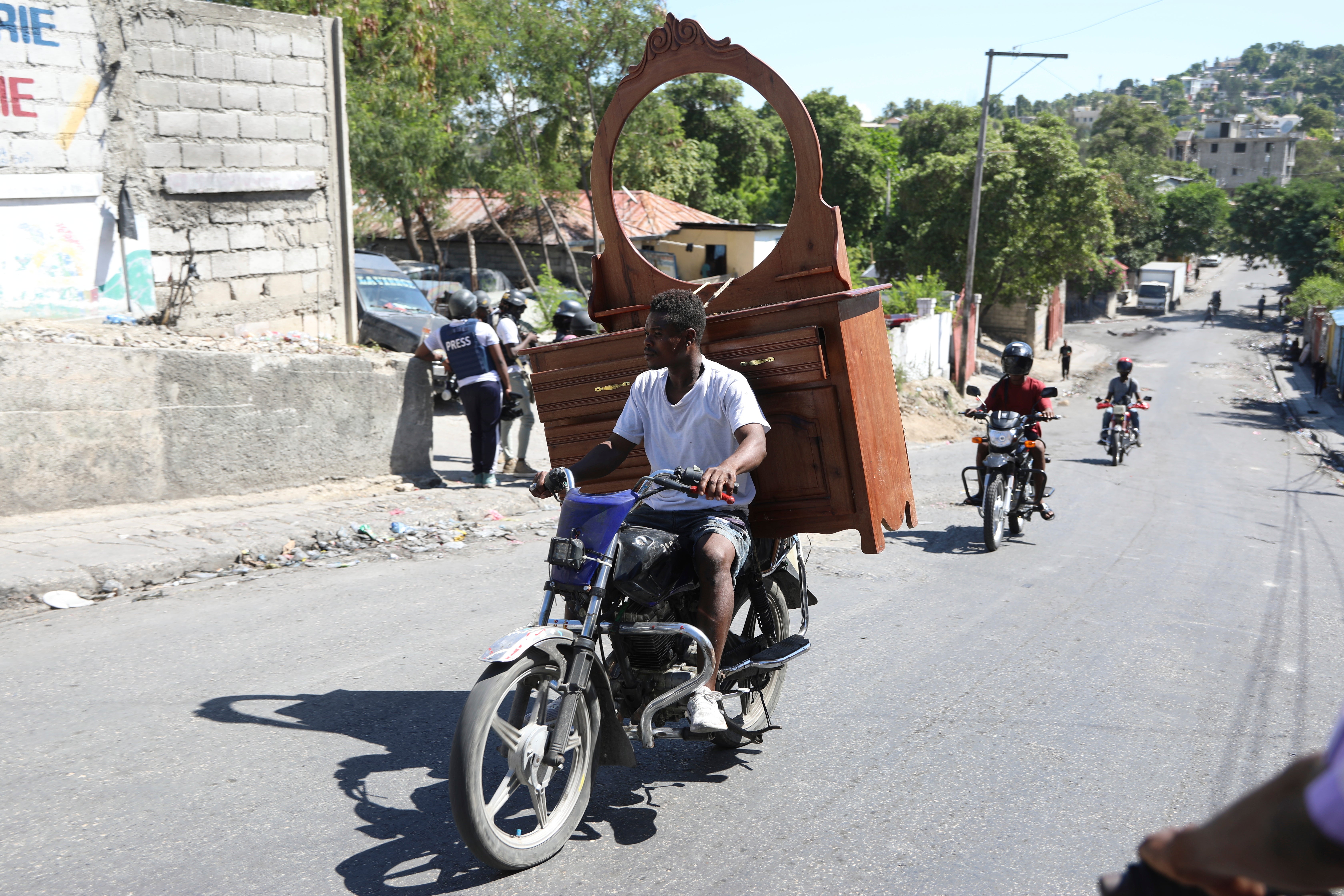 Um morador, com uma cômoda presa à traseira de sua motocicleta, foge de sua casa escapando da violência de gangues no bairro Solino, em Porto Príncipe, Haiti, sábado, 26 de outubro de 2024