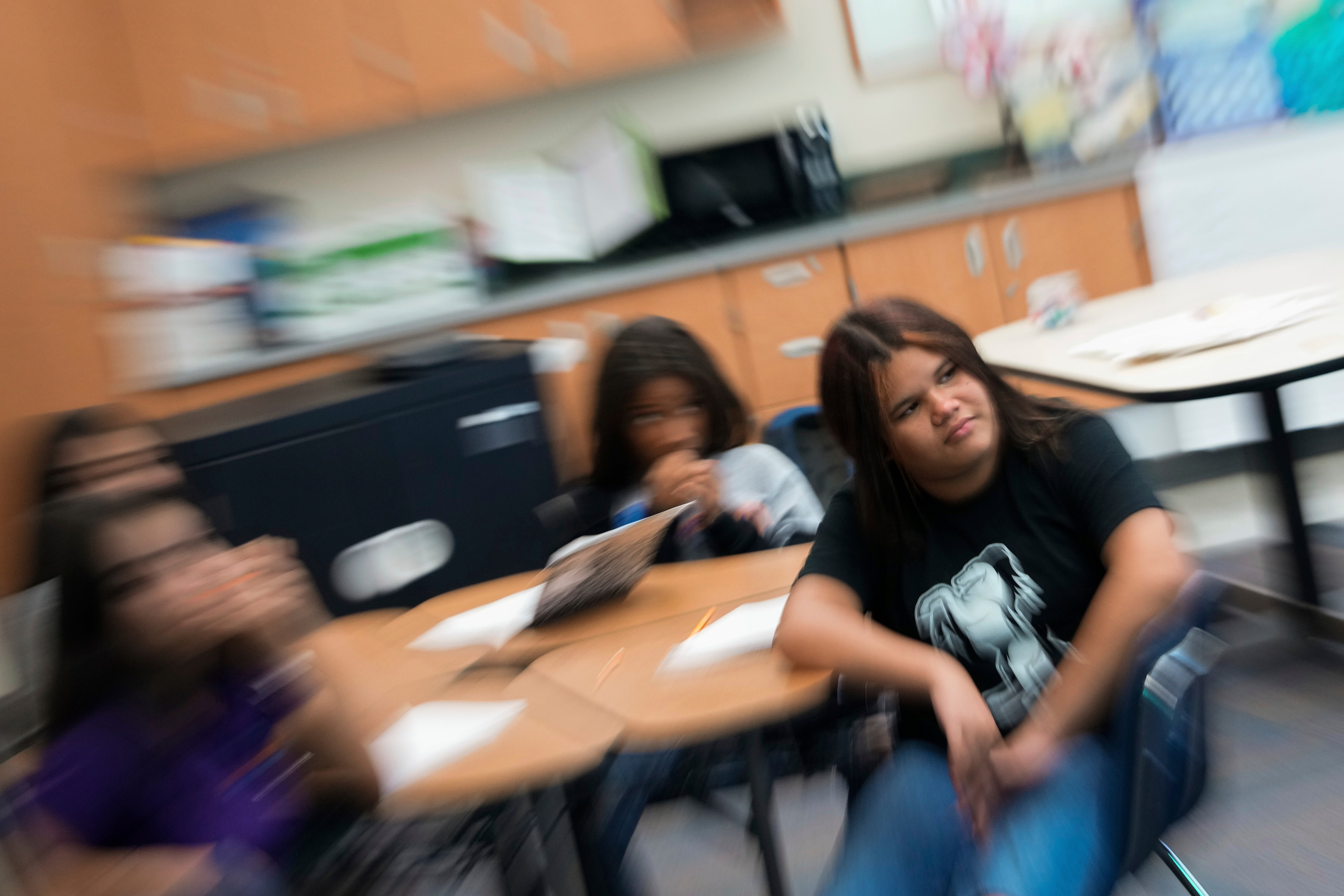 Alisson Ramírez, right, listens to her social studies teacher during class on August 28, 2024, in Aurora, Colorado. She is attending school in a city Trump has said is overrun by migrants