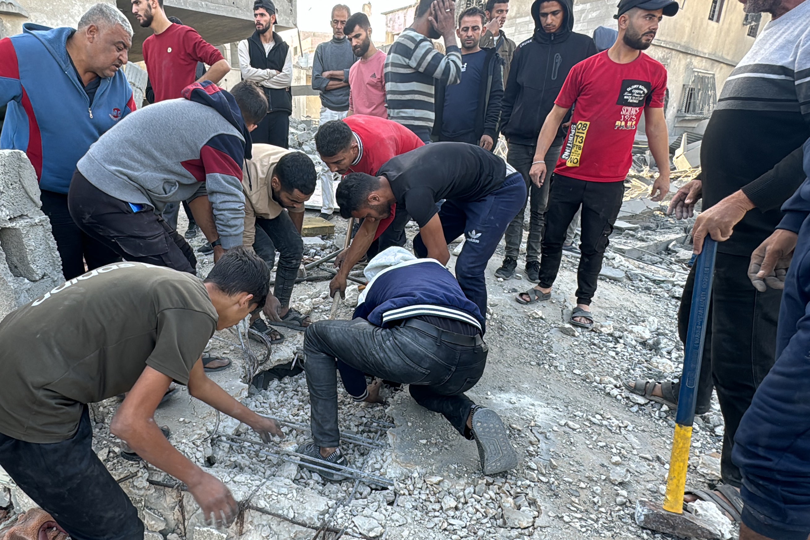 Palestinians search for survivors inside a destroyed building, hit in an overnight Israeli airstrike, in Beit Lahia the northern Gaza Strip on October 27