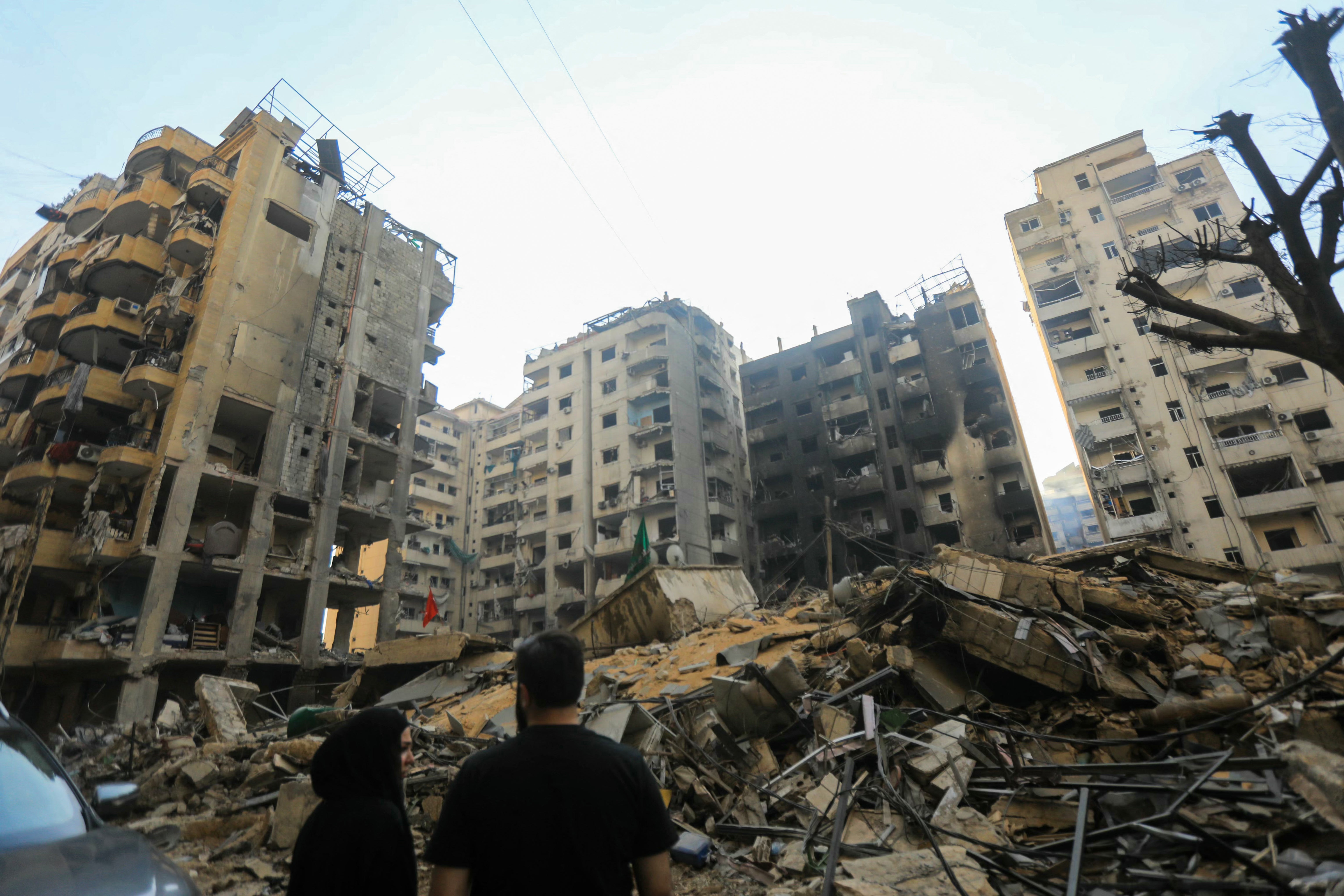 People inspect the destruction at the site of an overnight Israeli airstrike that targeted Beirut's southern suburbs