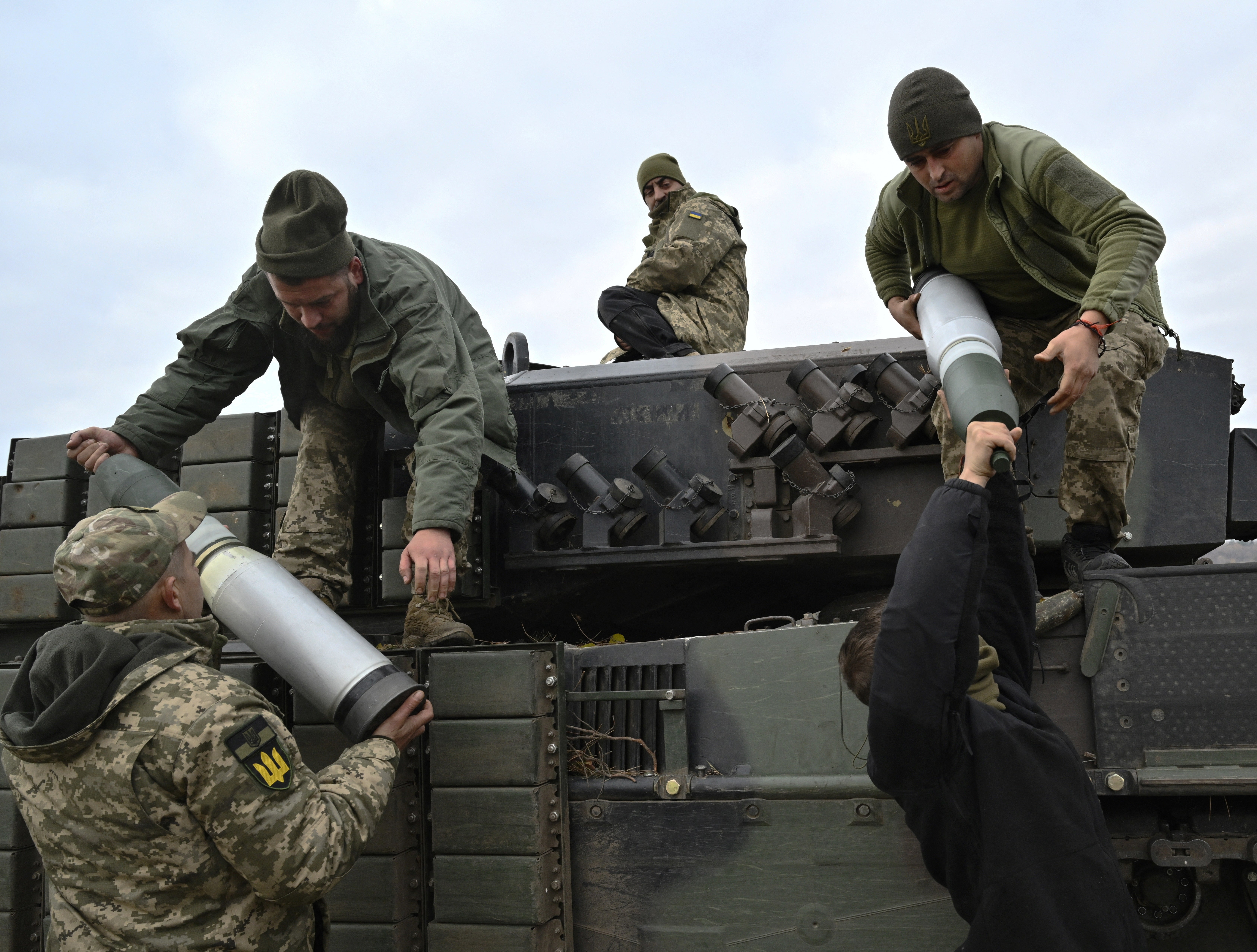 Tankers from the 33rd Separate Mechanized Brigade of the Ukrainian Ground Forces load projectiles onto a Leopard 2A4 tank