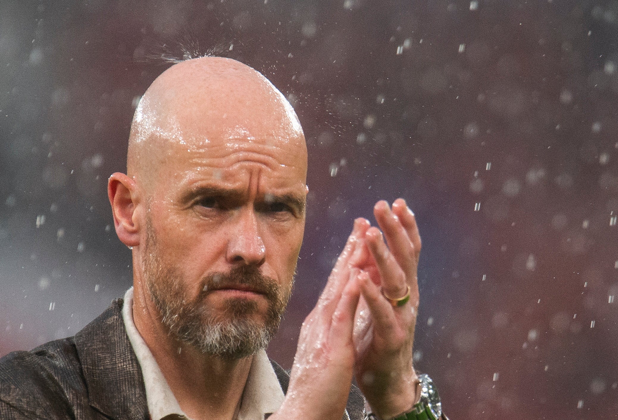 rain drop visibly lands on the head of Eric ten Hag manager of Manchester United as he salutes the crowd