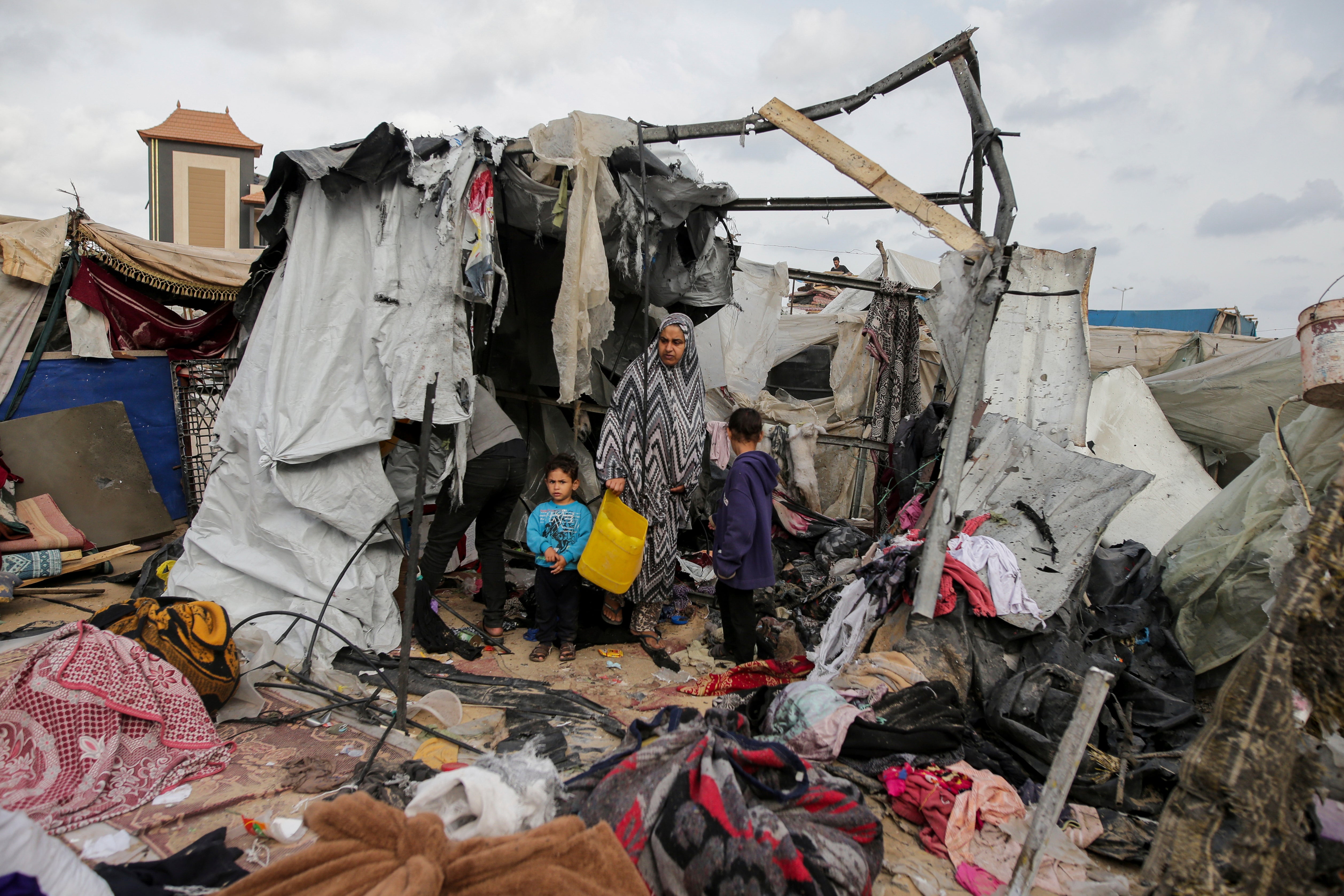 Displaced Palestinians inspect their tents destroyed by Israel’s bombardment