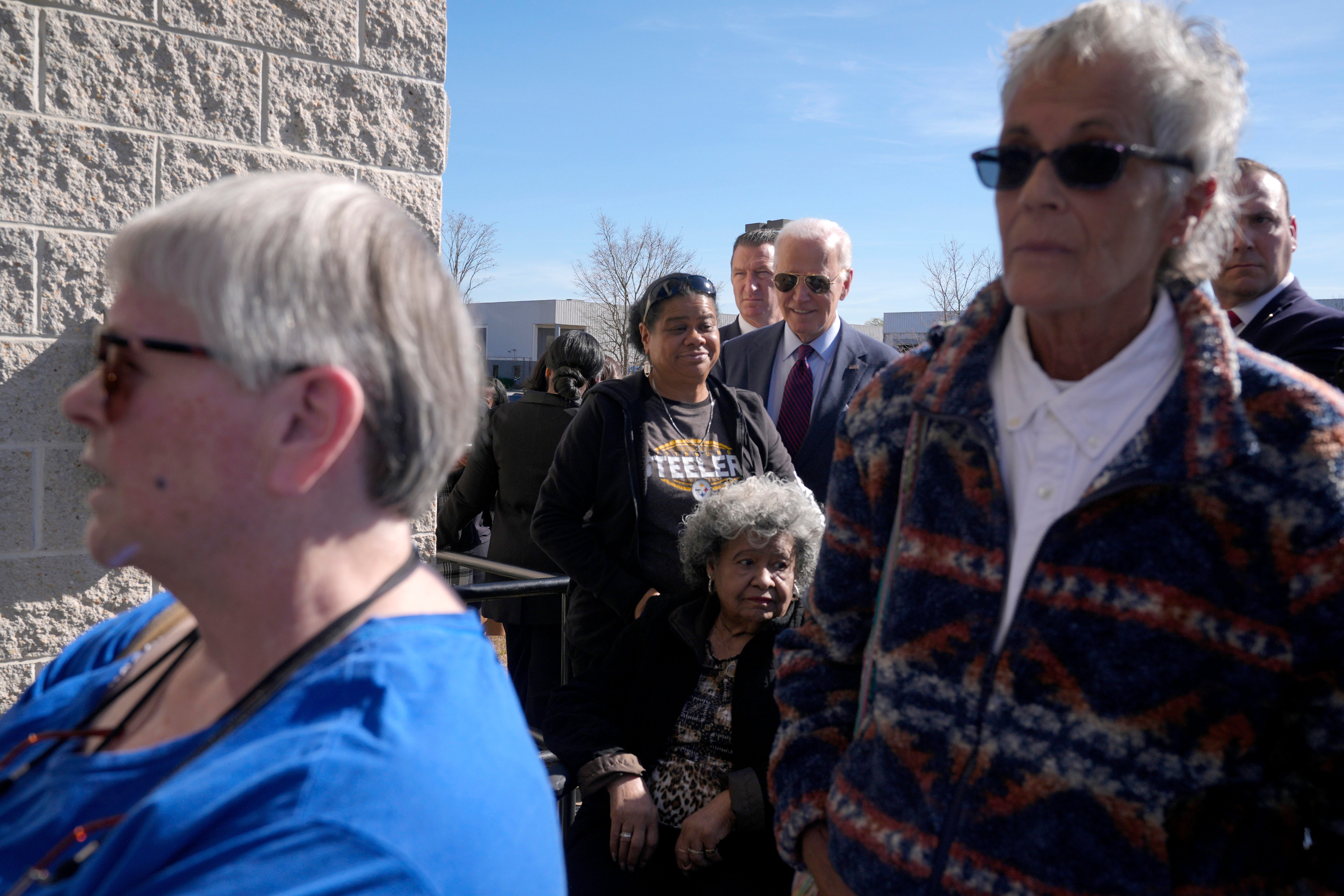 President Joe Biden, center, waits in line with other voters at a polling station to cast an early vote for the 2024 general election, Monday, Oct. 28, 2024, in New Castle, Del.