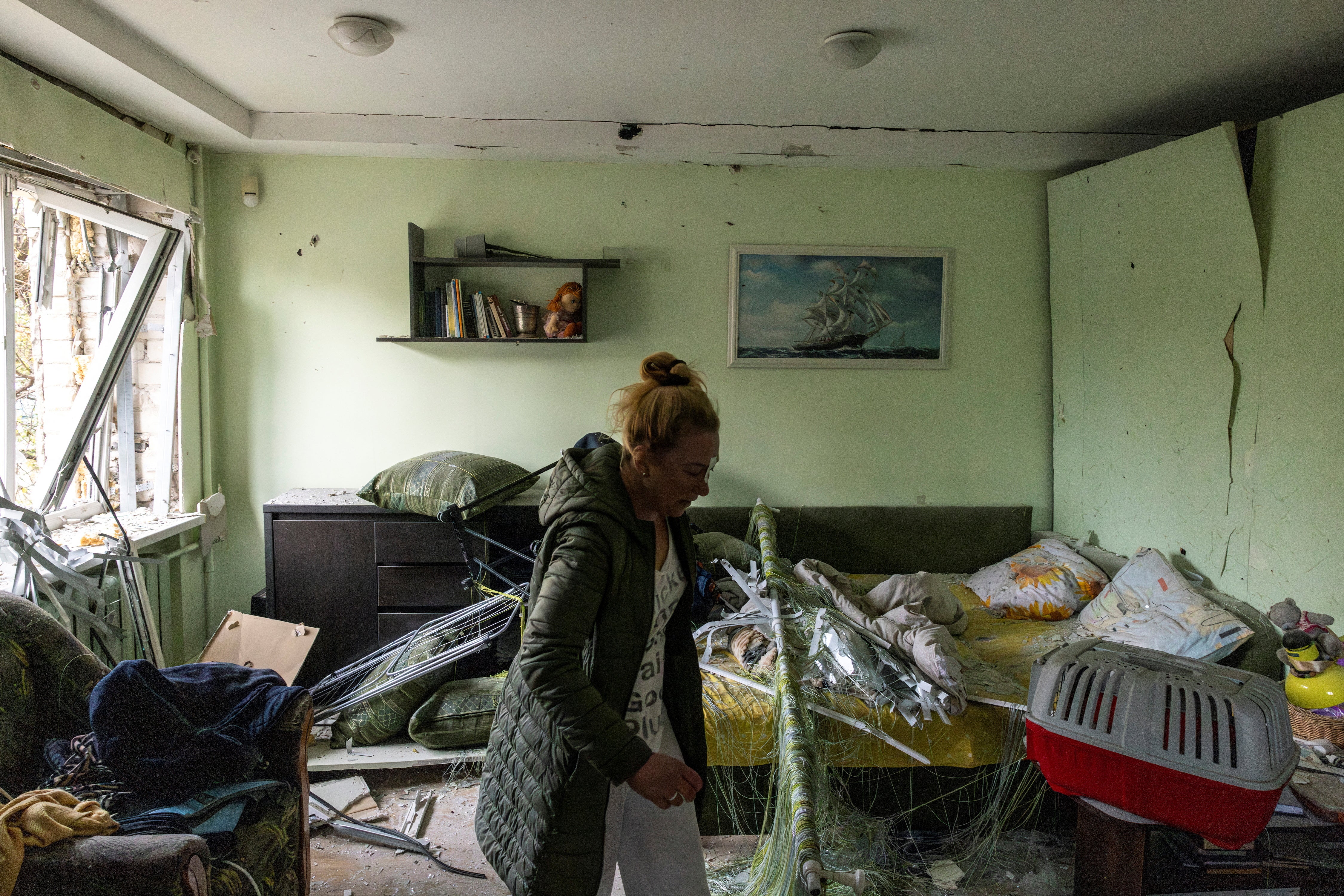 Vita Tkachenko, who was injured by flying debris while she was sleeping, examines the damage to her apartment after the crash of a Russian drone