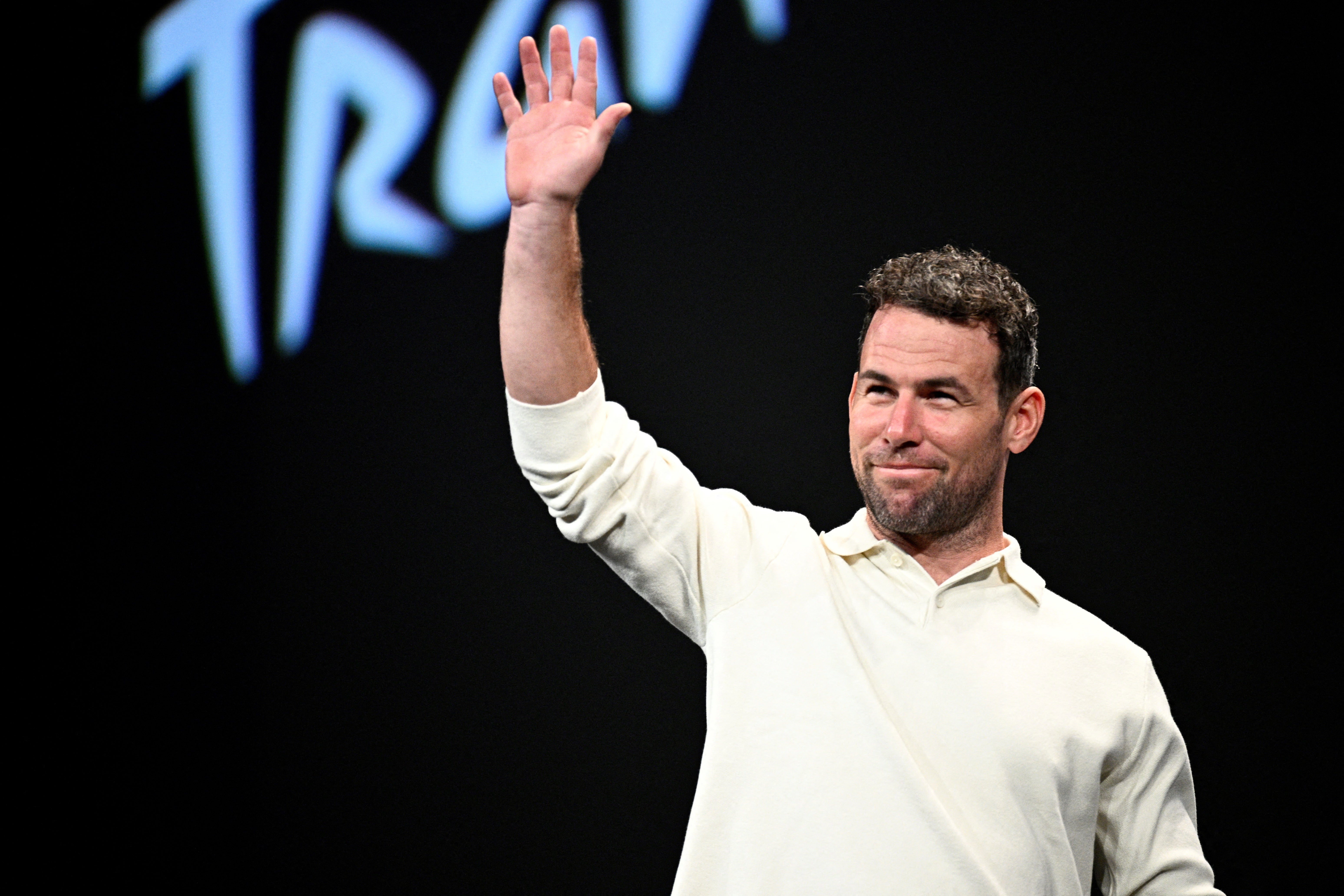 Mark Cavendish greets the crowd at the presentation for the 2025 Tour de France routes