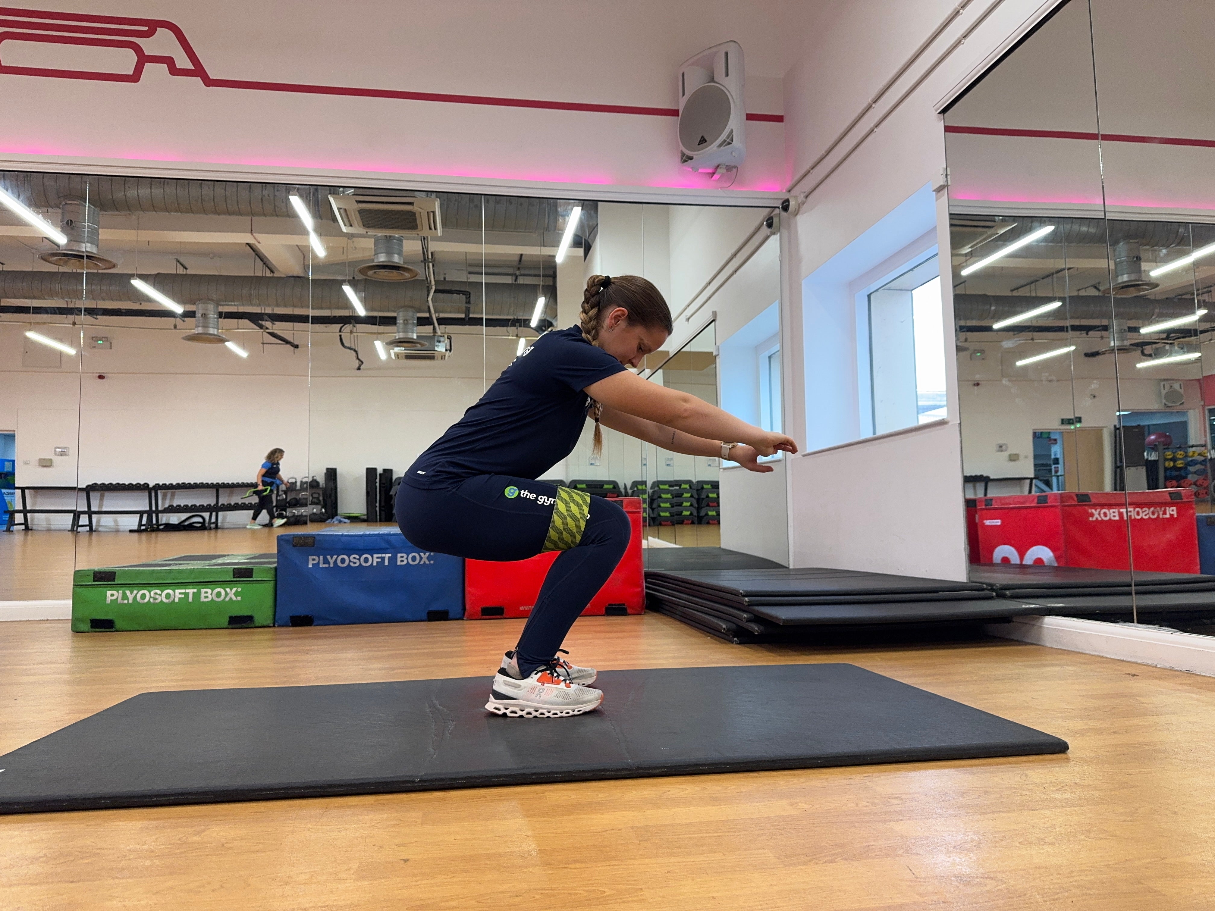 Trainer Sasha Bridgen demonstrating a banded squat and pulse