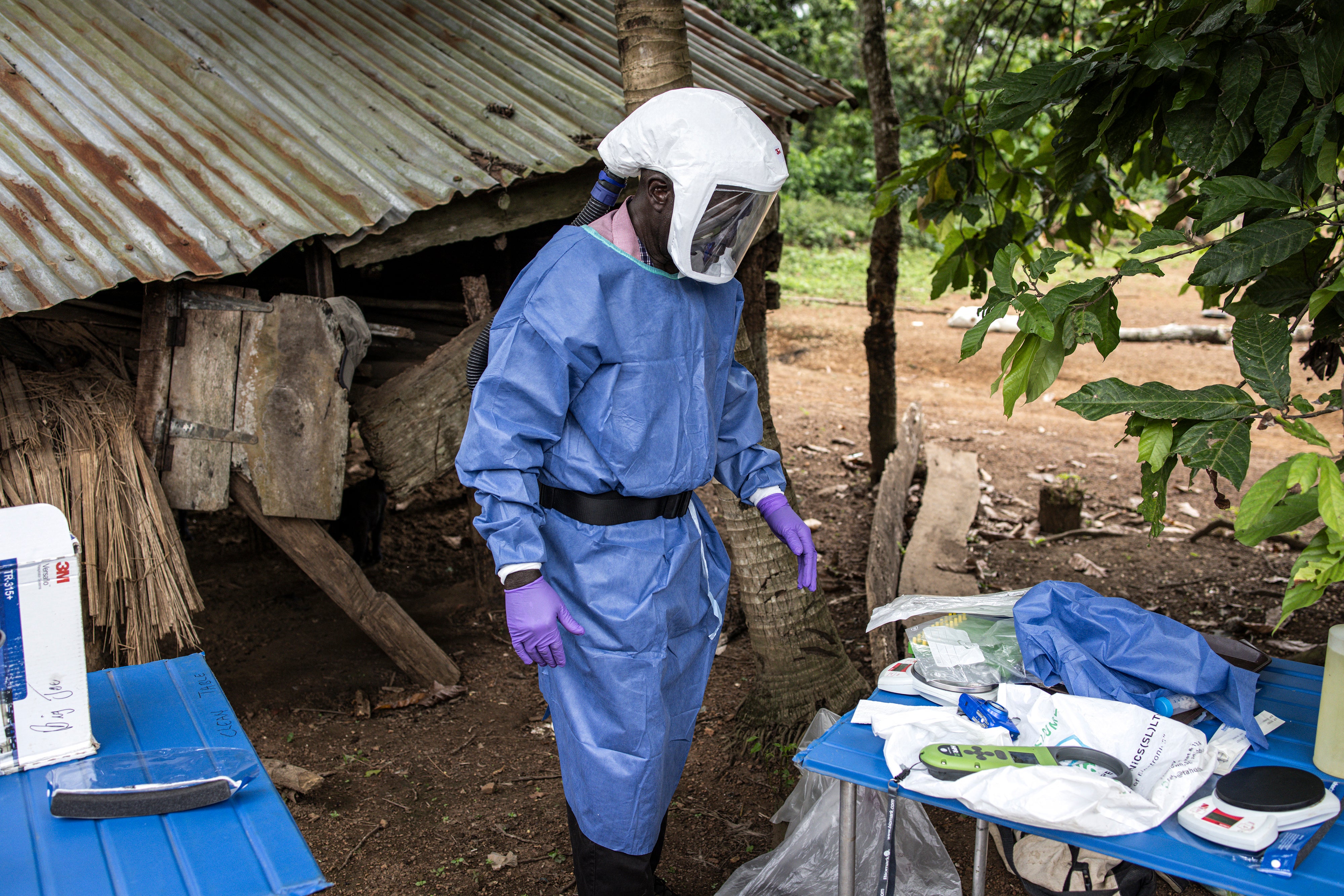 Kenema Government Hospital ecology team leader James Koninga (center) is seen wearing his personal protective equipment in Mapuma village outside Kenema on June 12, 2024