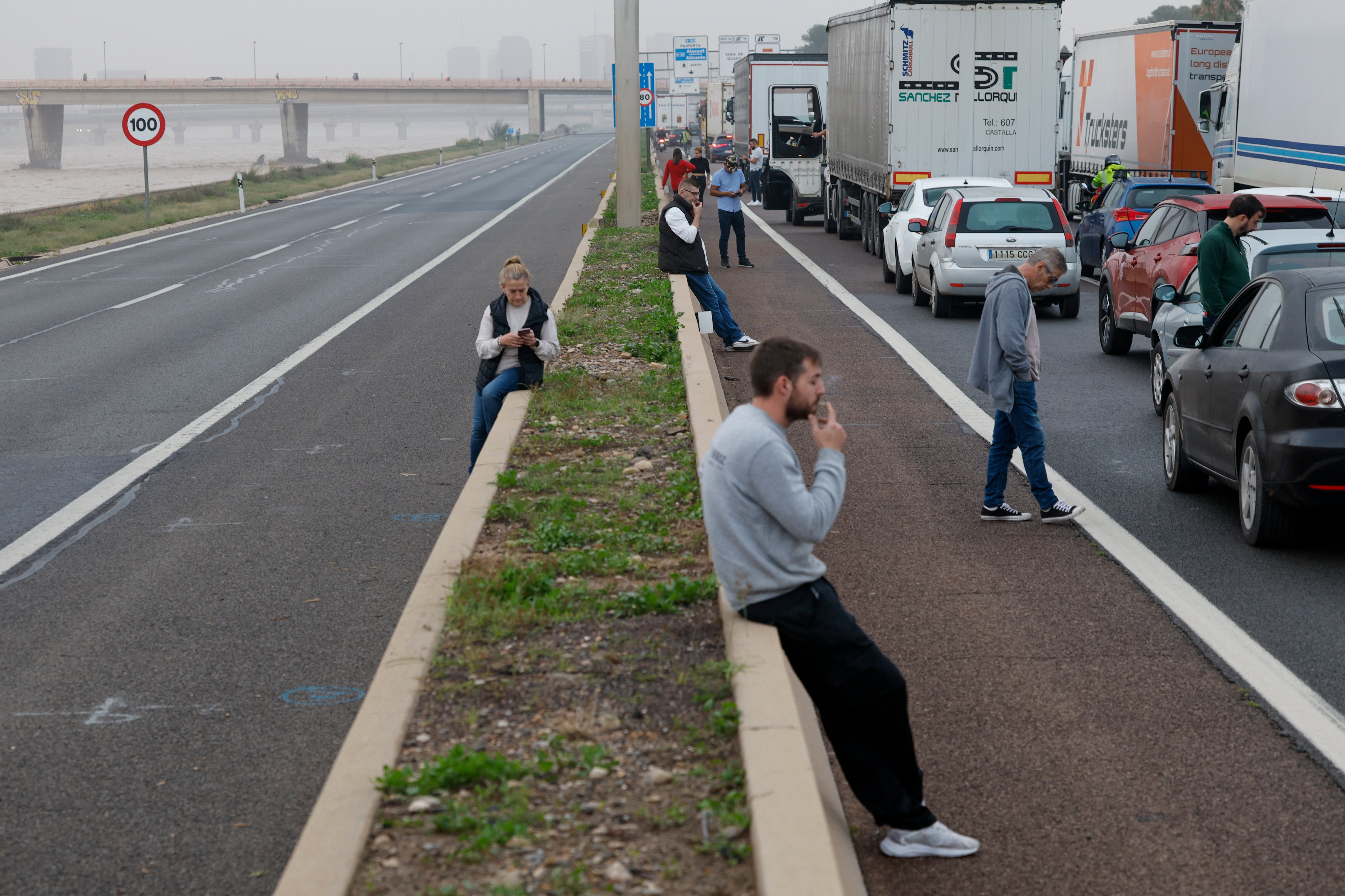 Traffic halted on a road near the Turia River with the highway network damaged by flooding