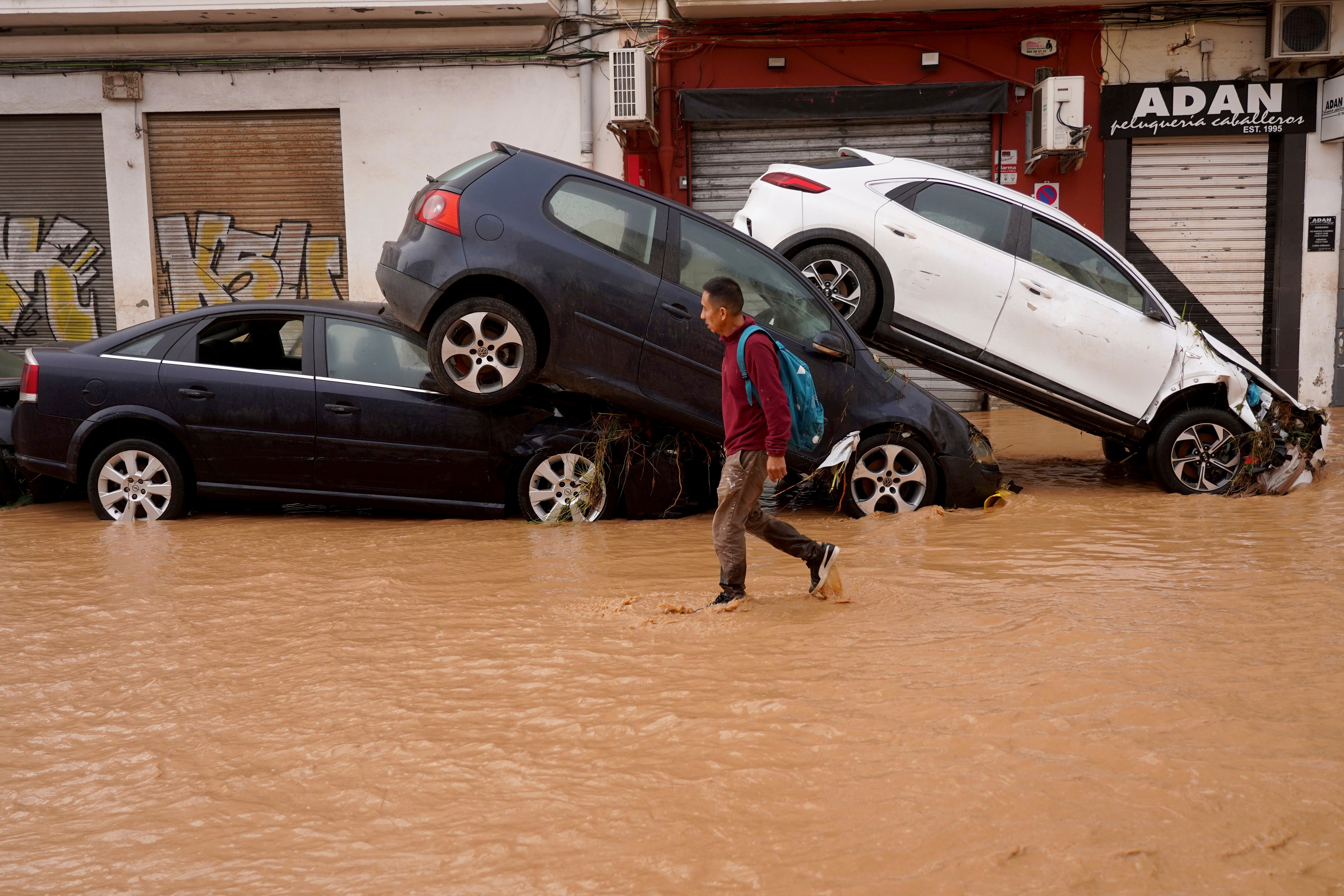 A person walks through a flooded street in Valencia