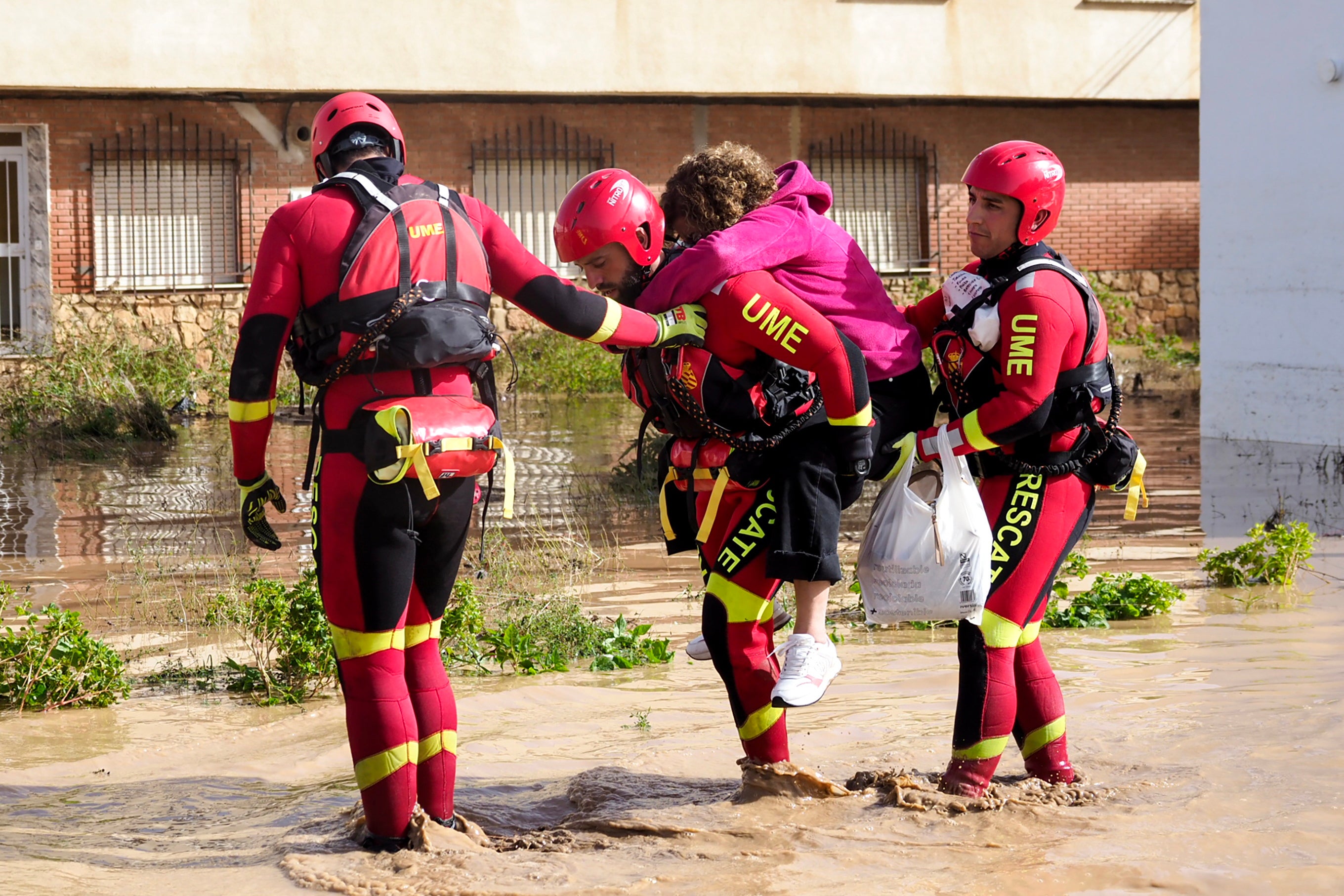 Members of Spain's Emergency Military Unit (UME) help a resident in the flood-affected municipality of Mira, Cuenca province