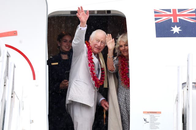 The King and Queen wave as they board a Royal Australian Air Force plane ahead of departing from Faleolo International Airport in Samoa (Chris Jackson/PA)