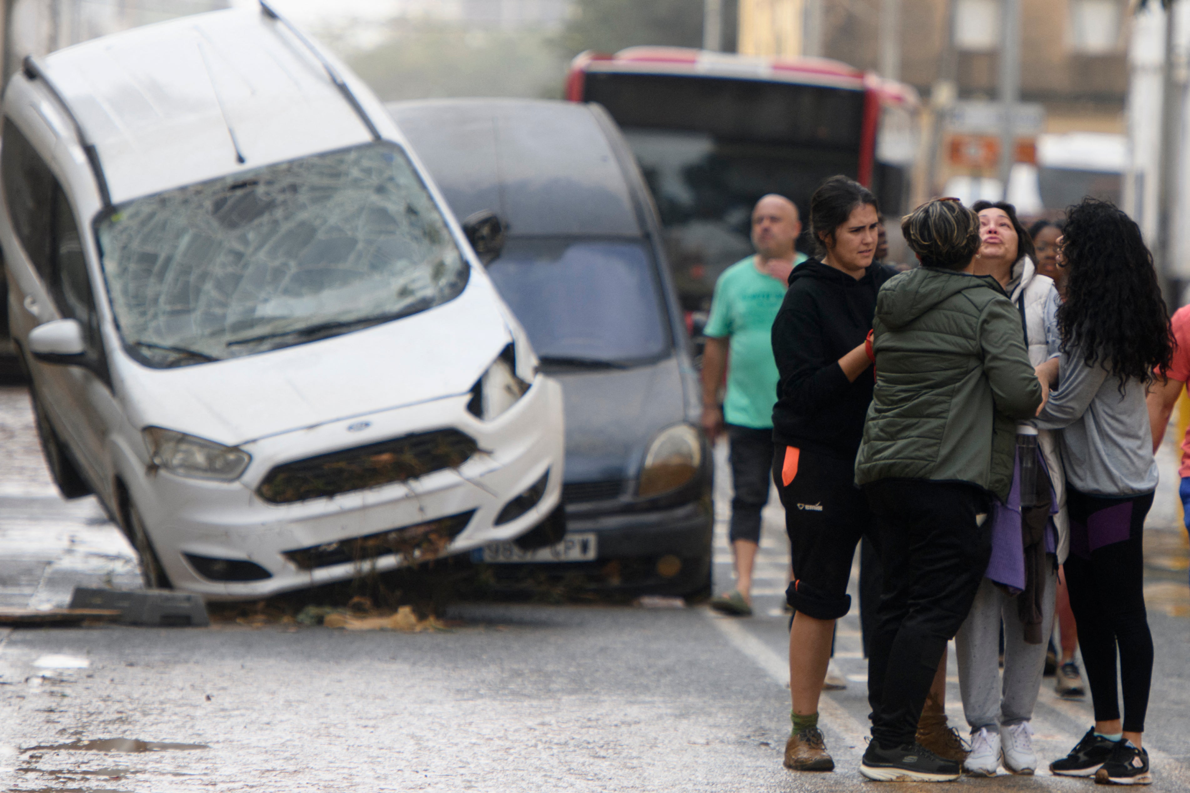 Residents talk on the street in front of a pile-up