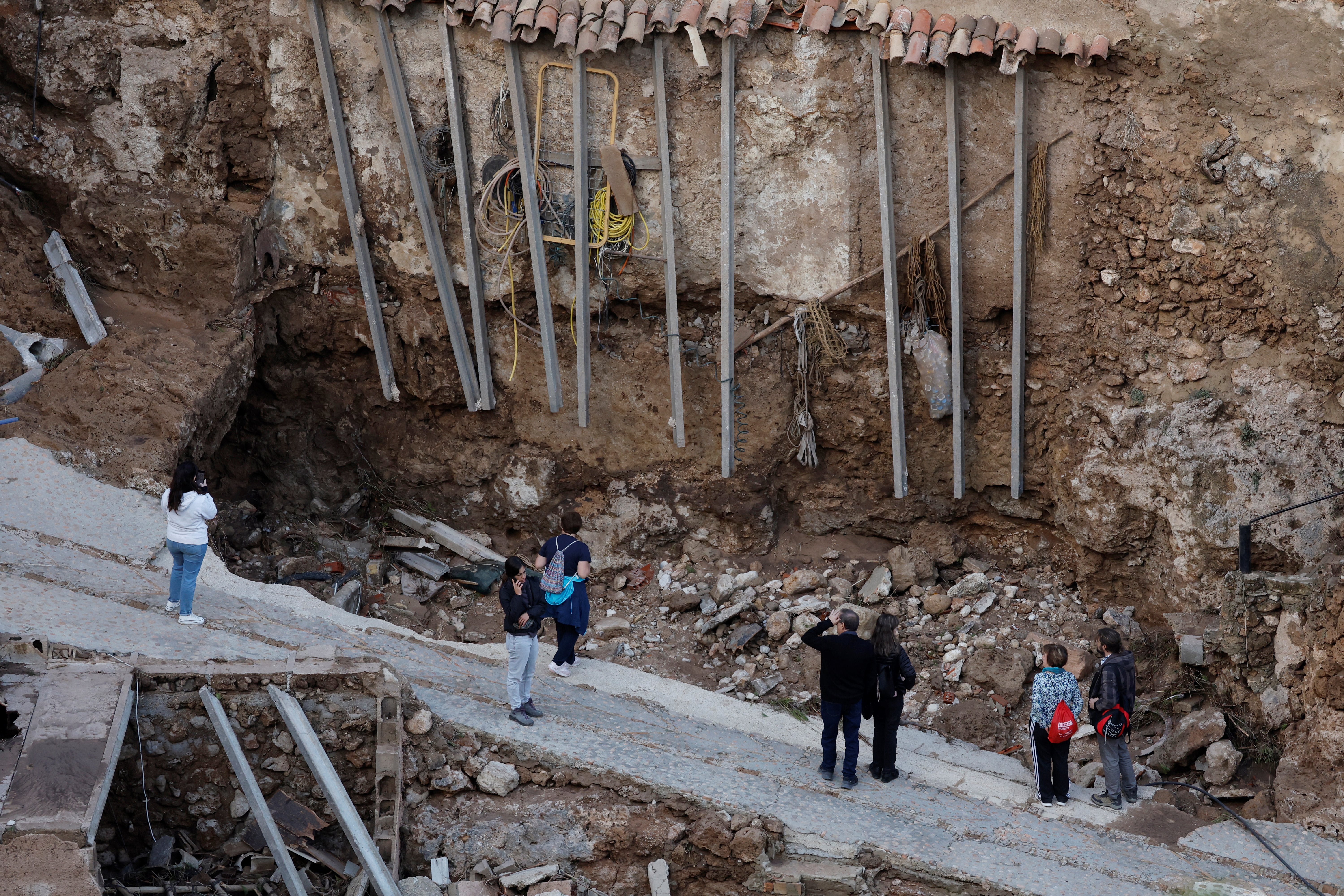 Residents look at damaged road and houses following floods in Letur, southwest of Valencia, eastern Spain