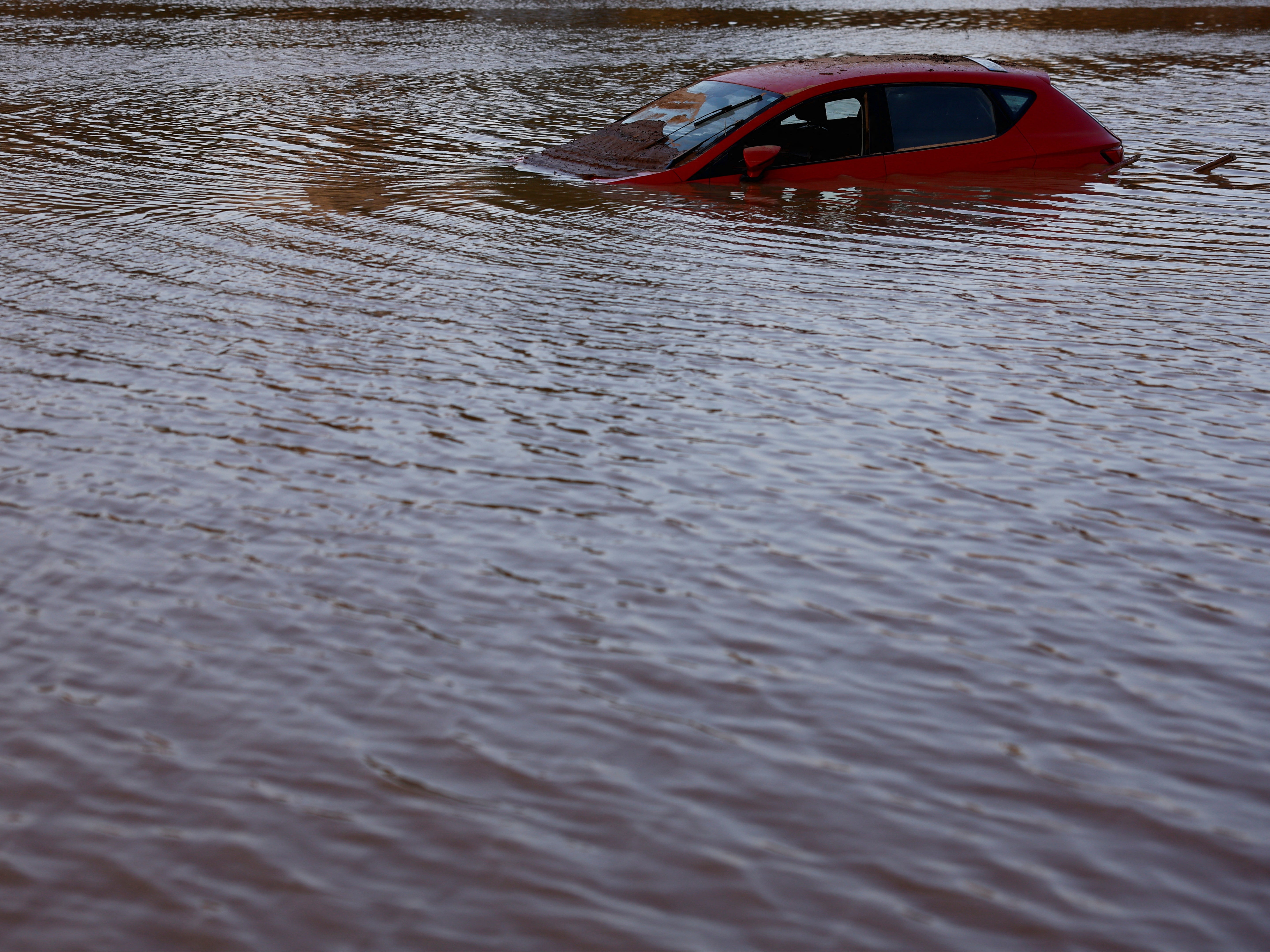 A car lies partially submerged after floods in Utiel