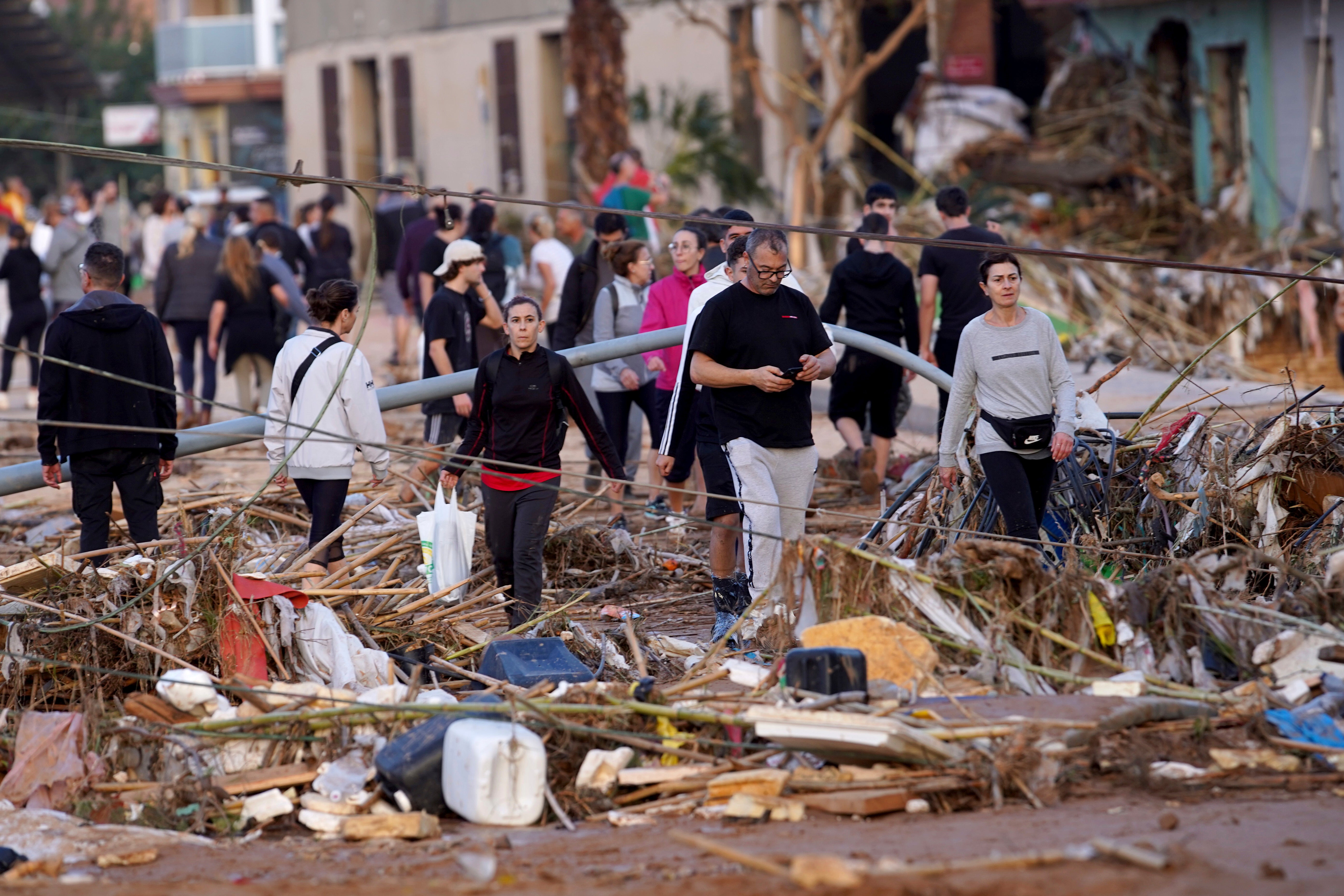 <p>Residents walk in a street after flooding in Paiporta, near Valencia, Spain</p>